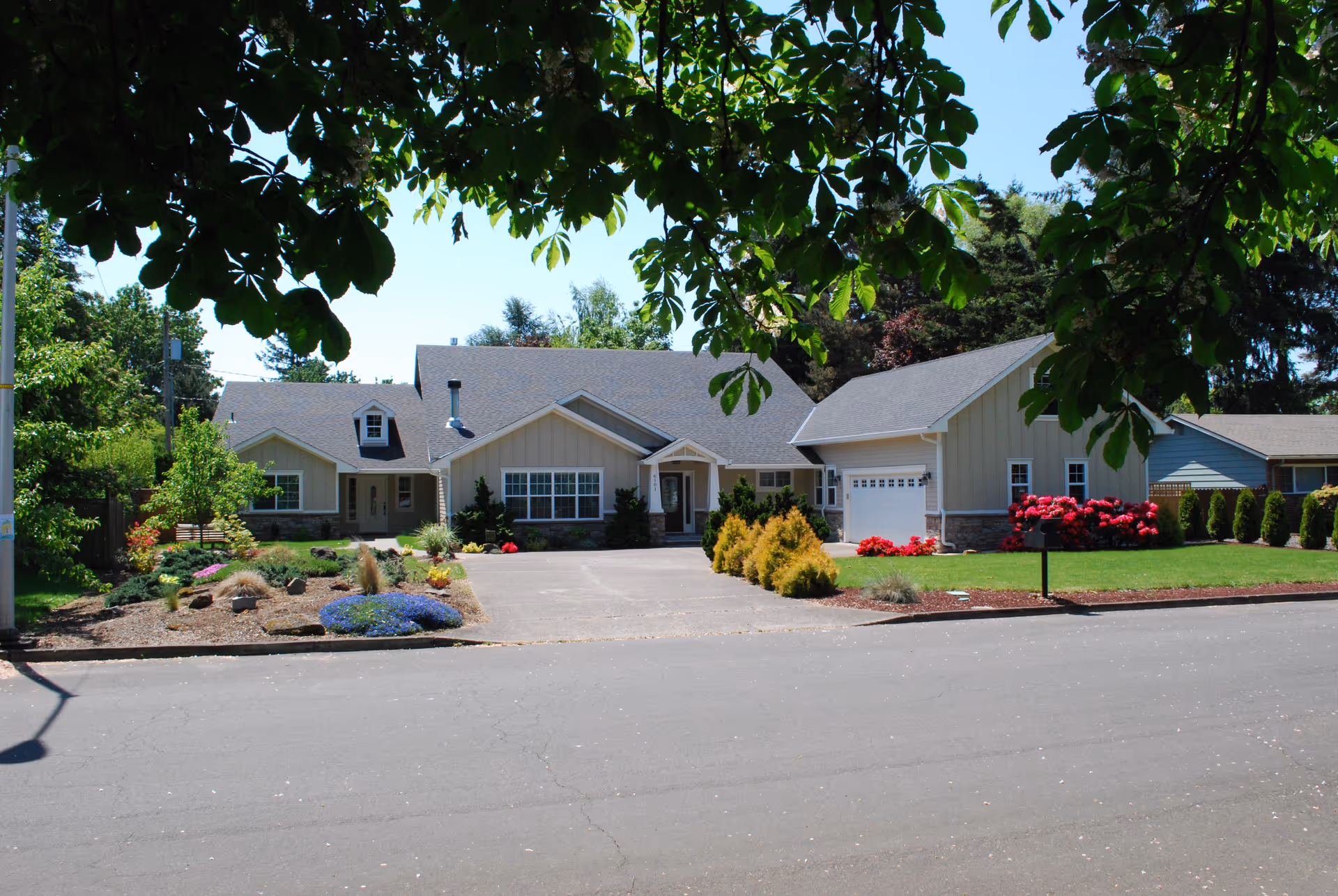 Front view of a single-story senior living facility with landscaped lawn and driveway.