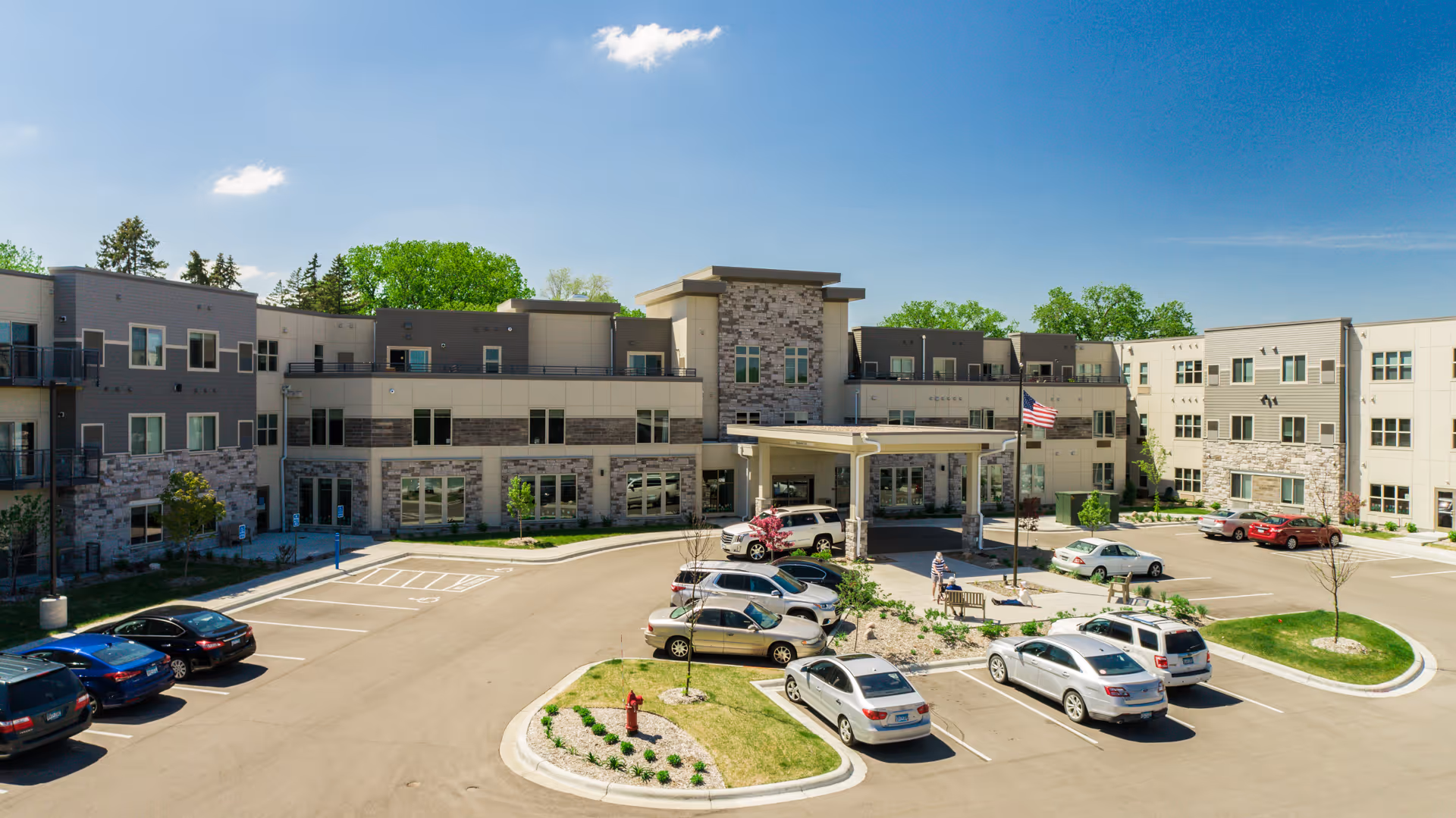 Exterior view of Havenwood of Minnetonka, a modern senior living campus with central entrance and parking.