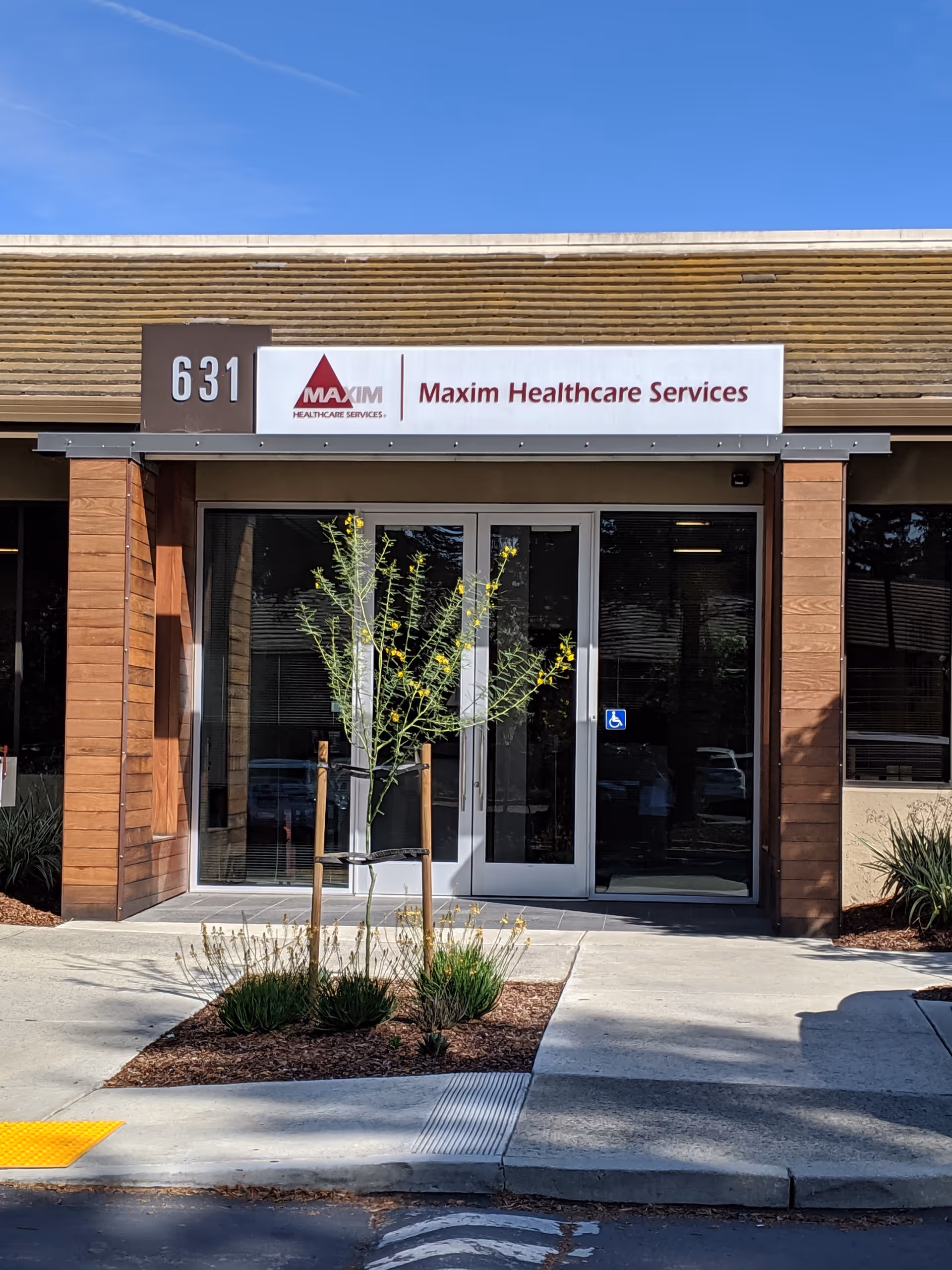 Front entrance of Maxim Healthcare San Jose office with glass doors and landscaping.