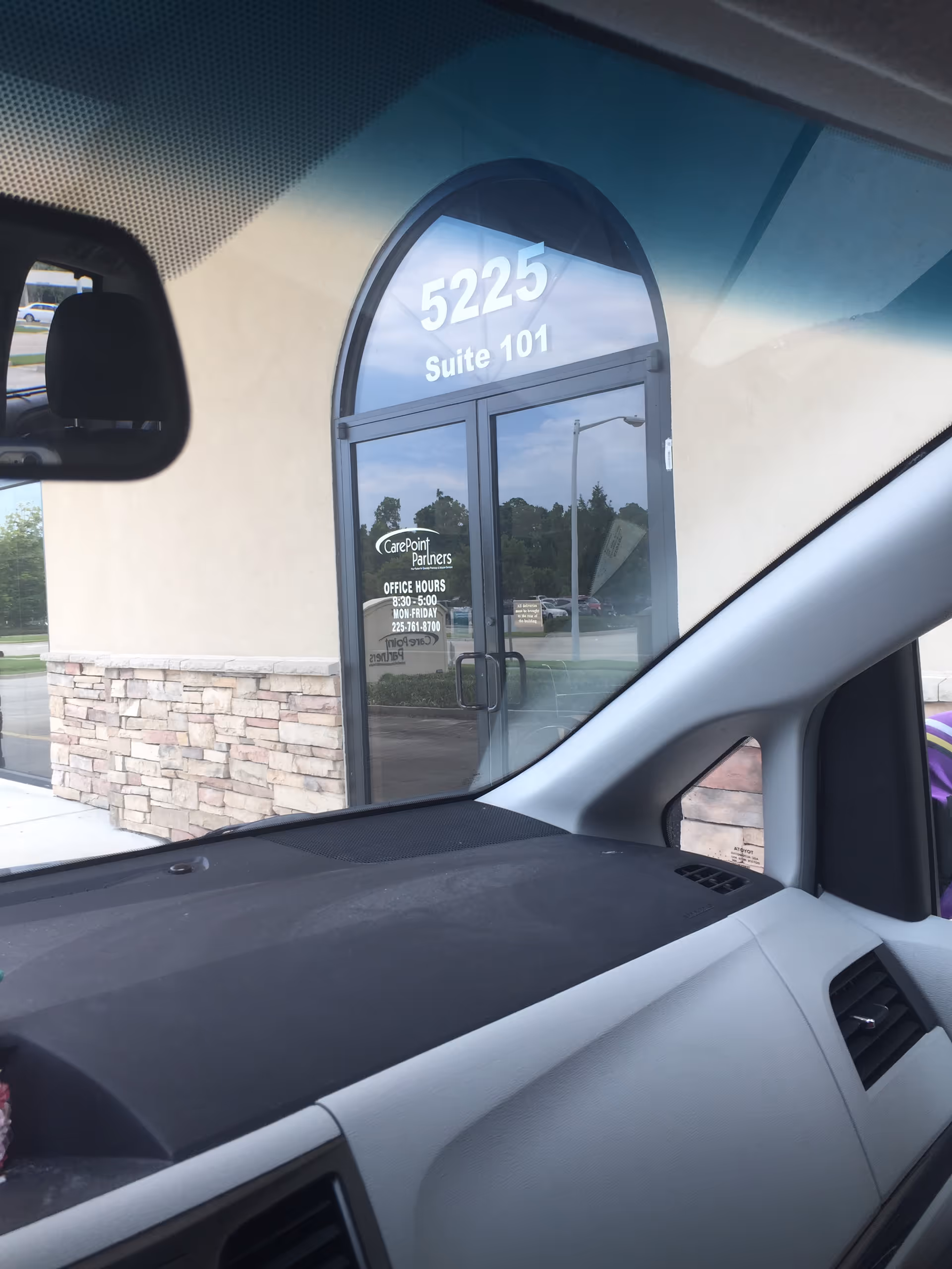 View from inside a car of CarePoint Partners building entrance, suite 101.
