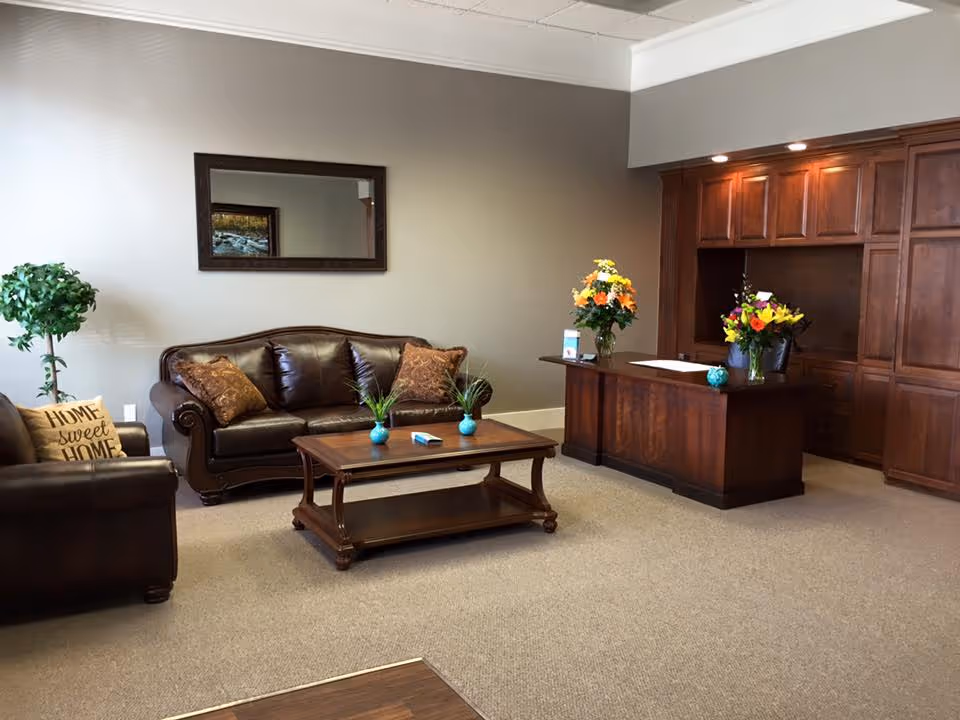 Warm leather seating area in a senior living lobby with a reception desk.