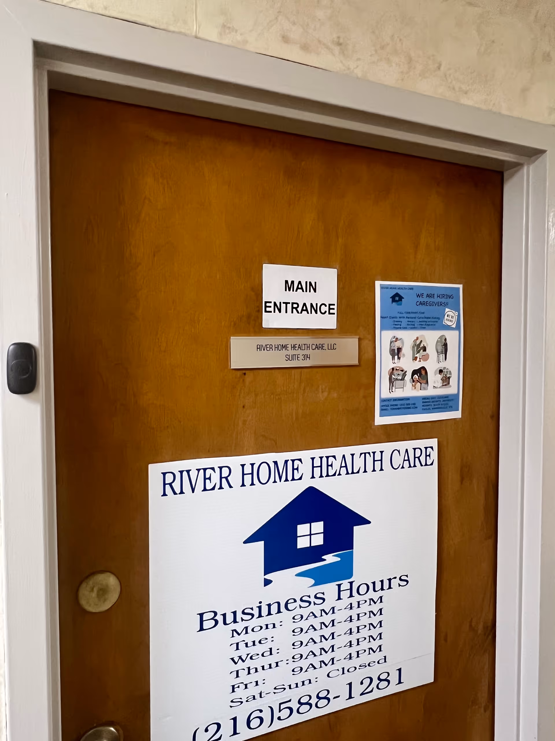 Wooden interior door with Main Entrance sign and River Home Health Care poster.
