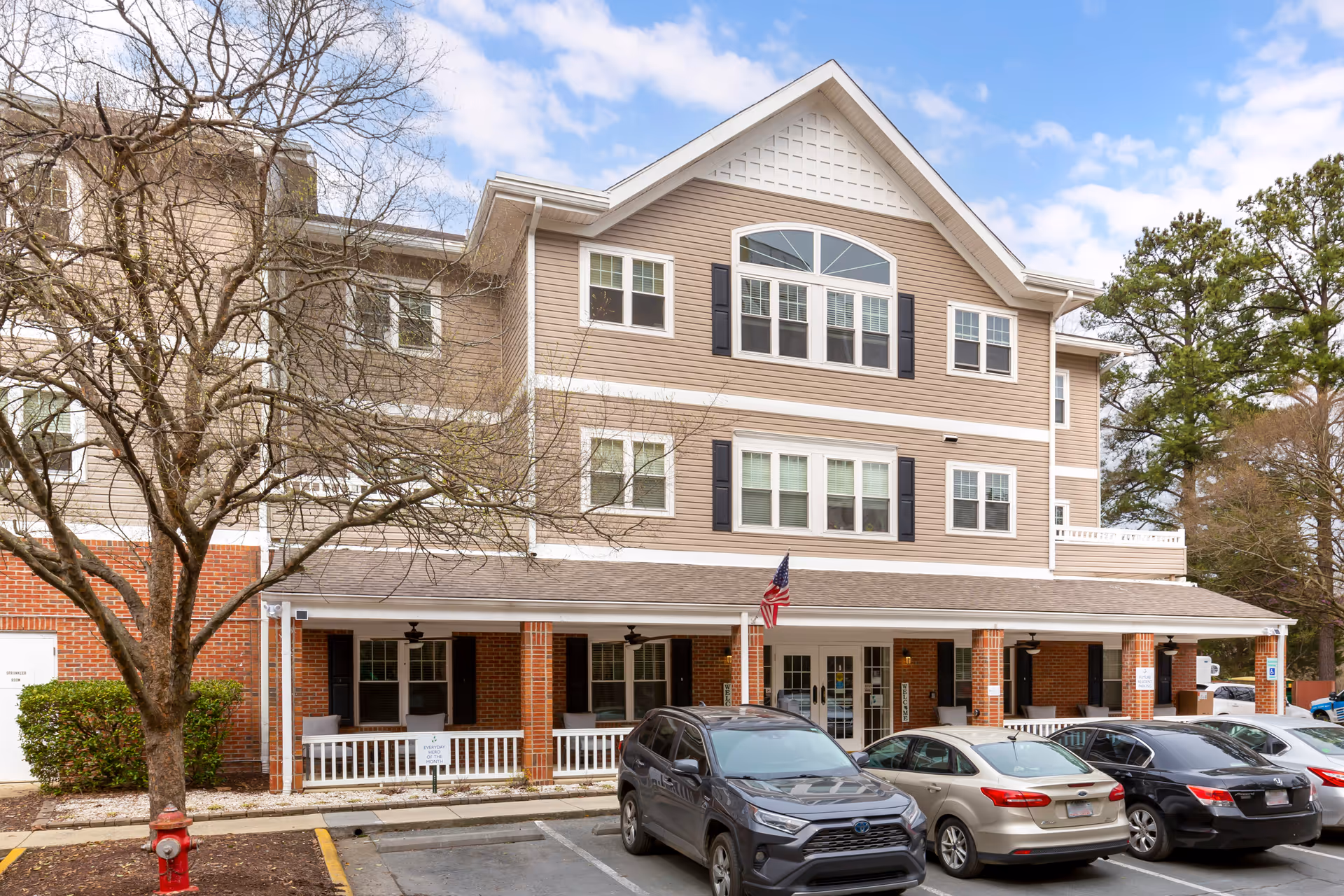 Front exterior of Brookdale Meadowmont, a three-story beige-siding building with brick base.