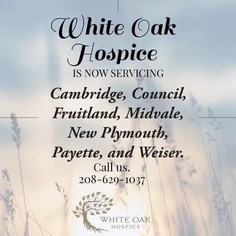 Outdoor sign displaying White Oak Hospice service areas and contact number against a blurred field.