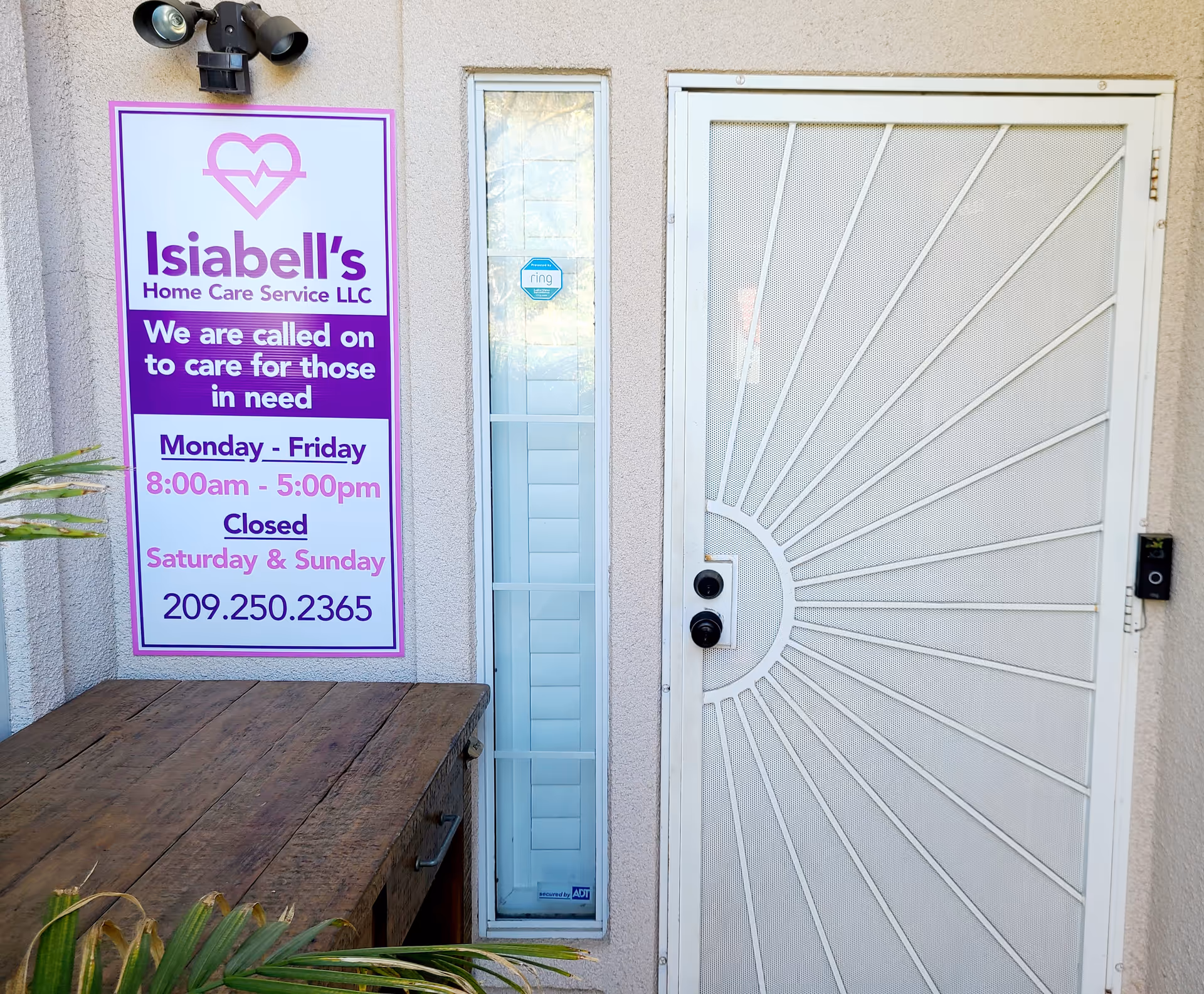 Exterior view of a building front with a purple Isiabell's Home Care sign and entry door.
