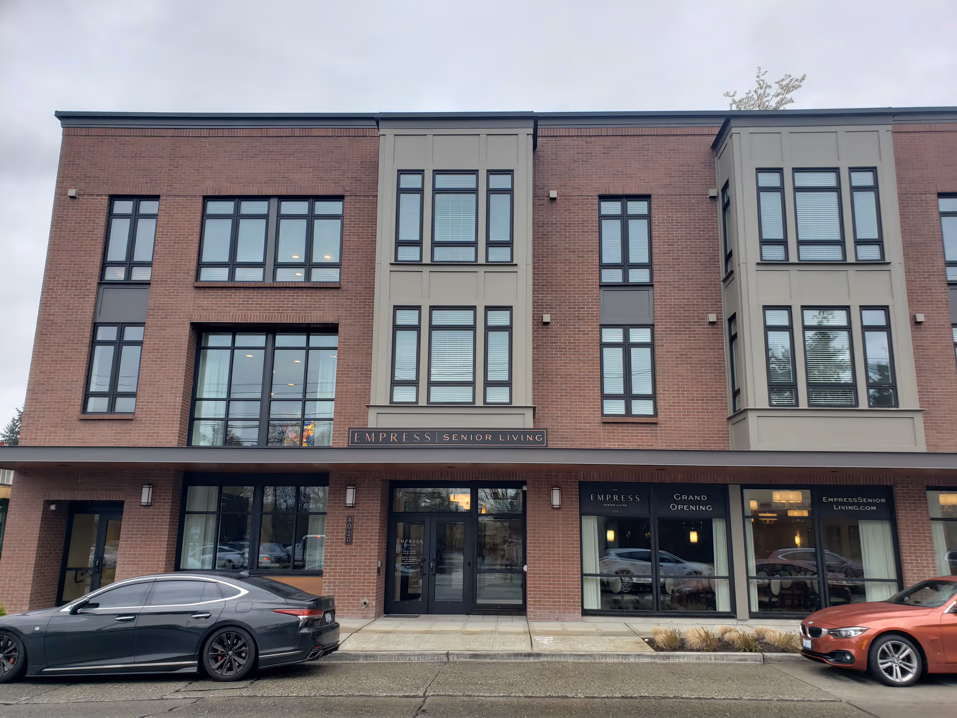 Brick three-story building with Empress Senior Living at Laurelhurst sign and glass storefronts.