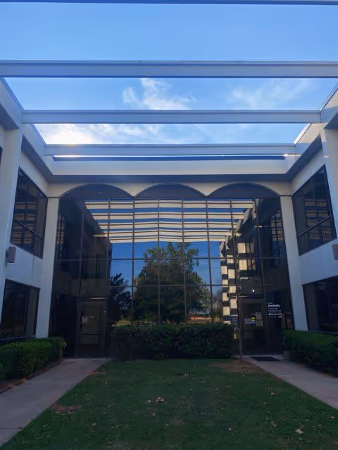 Front view of Monarch Hospice of Oklahoma building entrance with glass facade.