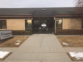 Front exterior of Enhabit Home Health & Hospice regional office with glass doors and walkway.