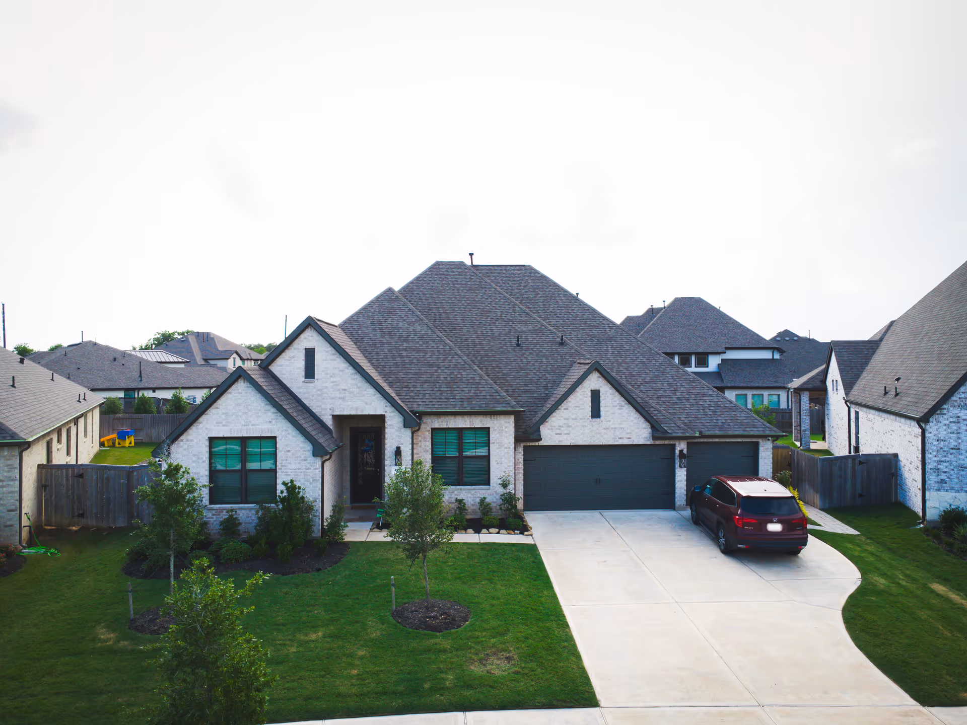 A suburban single-family home with a two-car garage and well-kept front lawn.