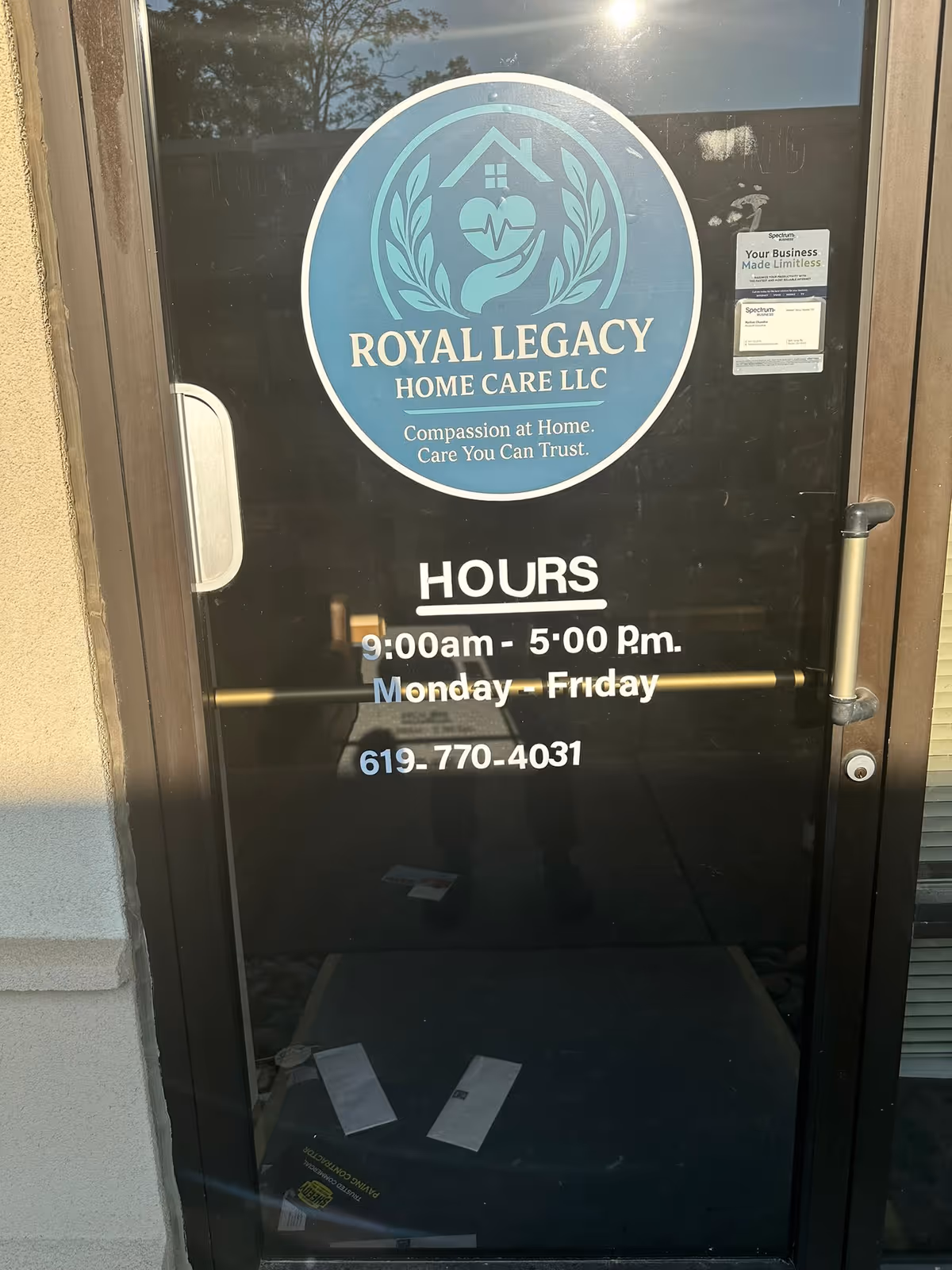 Glass door displays Royal Legacy Home Care logo and hours of operation.