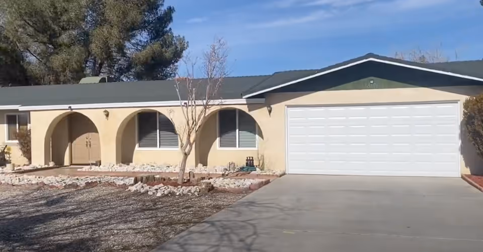 Front view of a single-story residence with arched entryways and a two-car garage.