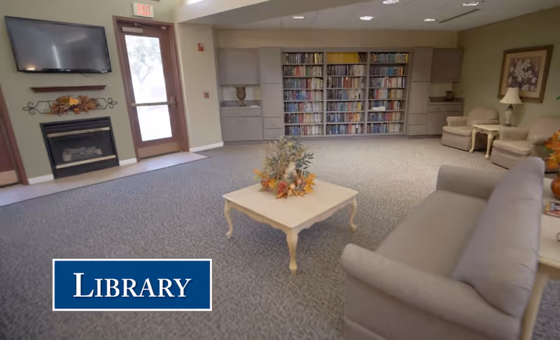 Cozy library lounge at Good Samaritan Society White Acres with bookshelves and seating.