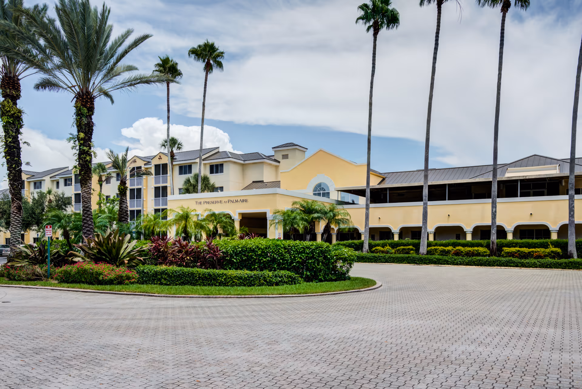 Front exterior of The Preserve at Palm-Aire with palm trees and circular driveway.