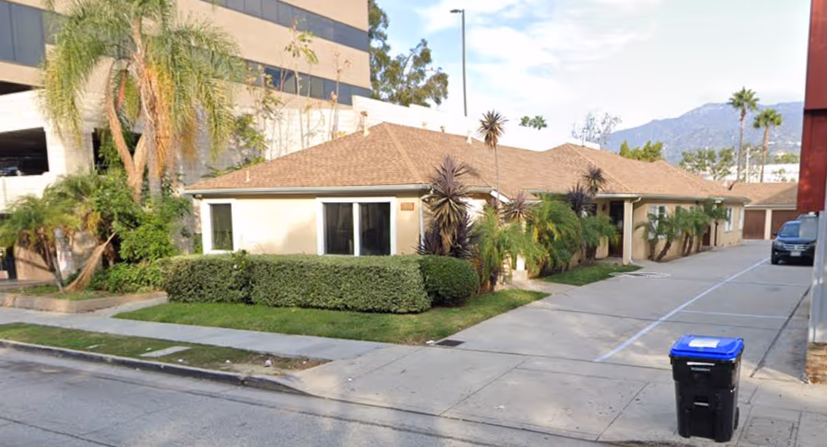 Exterior view of Narvista Home Health Agency, a single-story beige building with palm trees.