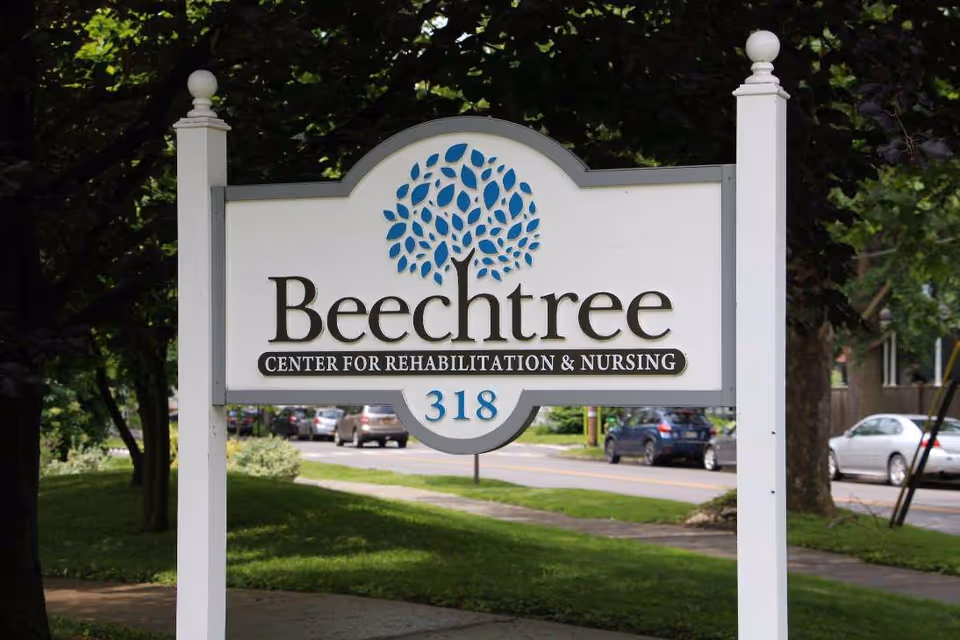 White sign reads Beechtree Center for Rehabilitation & Nursing in front of trees.
