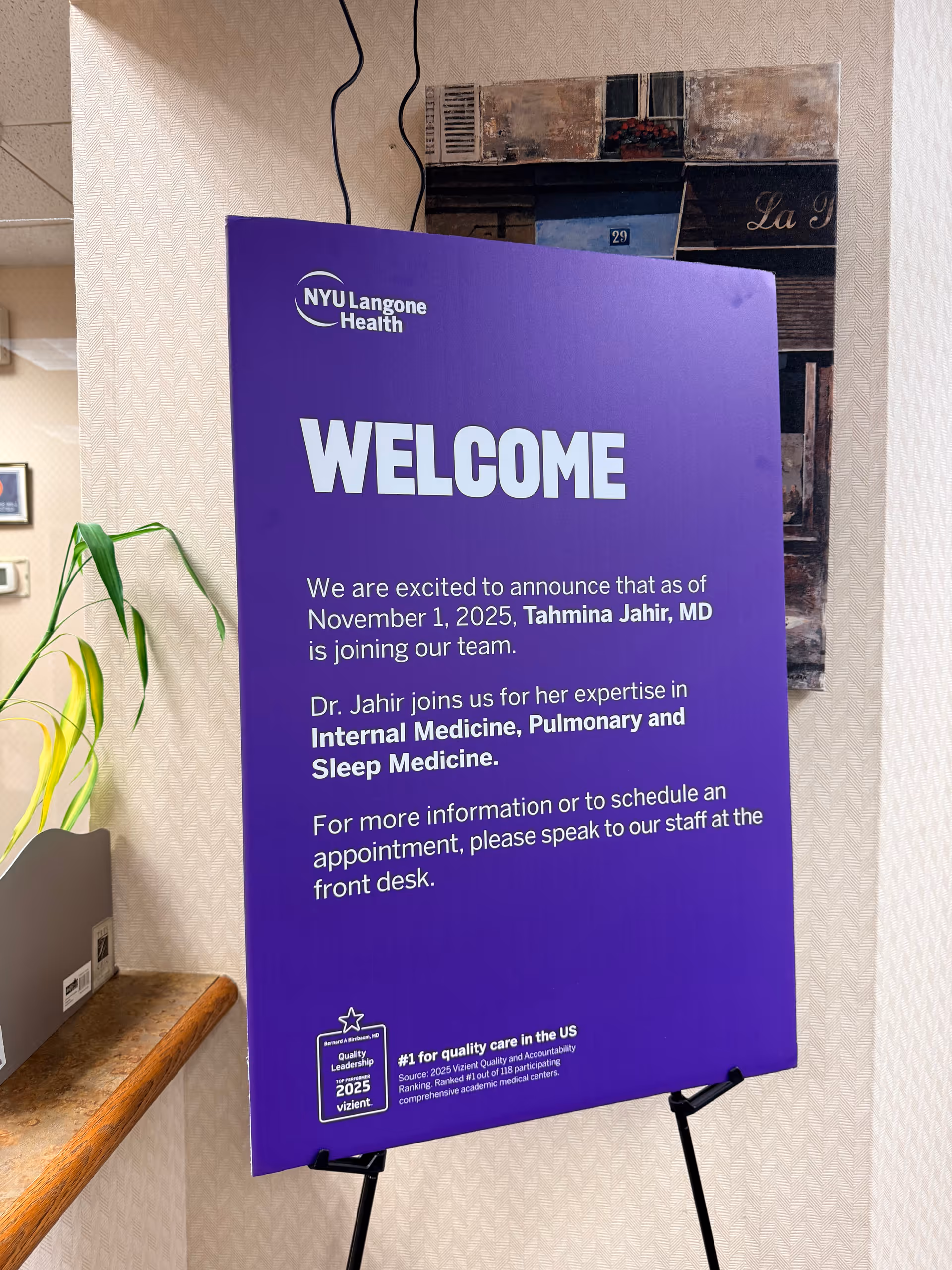 Purple NYU Langone Health welcome sign in a hallway interior.