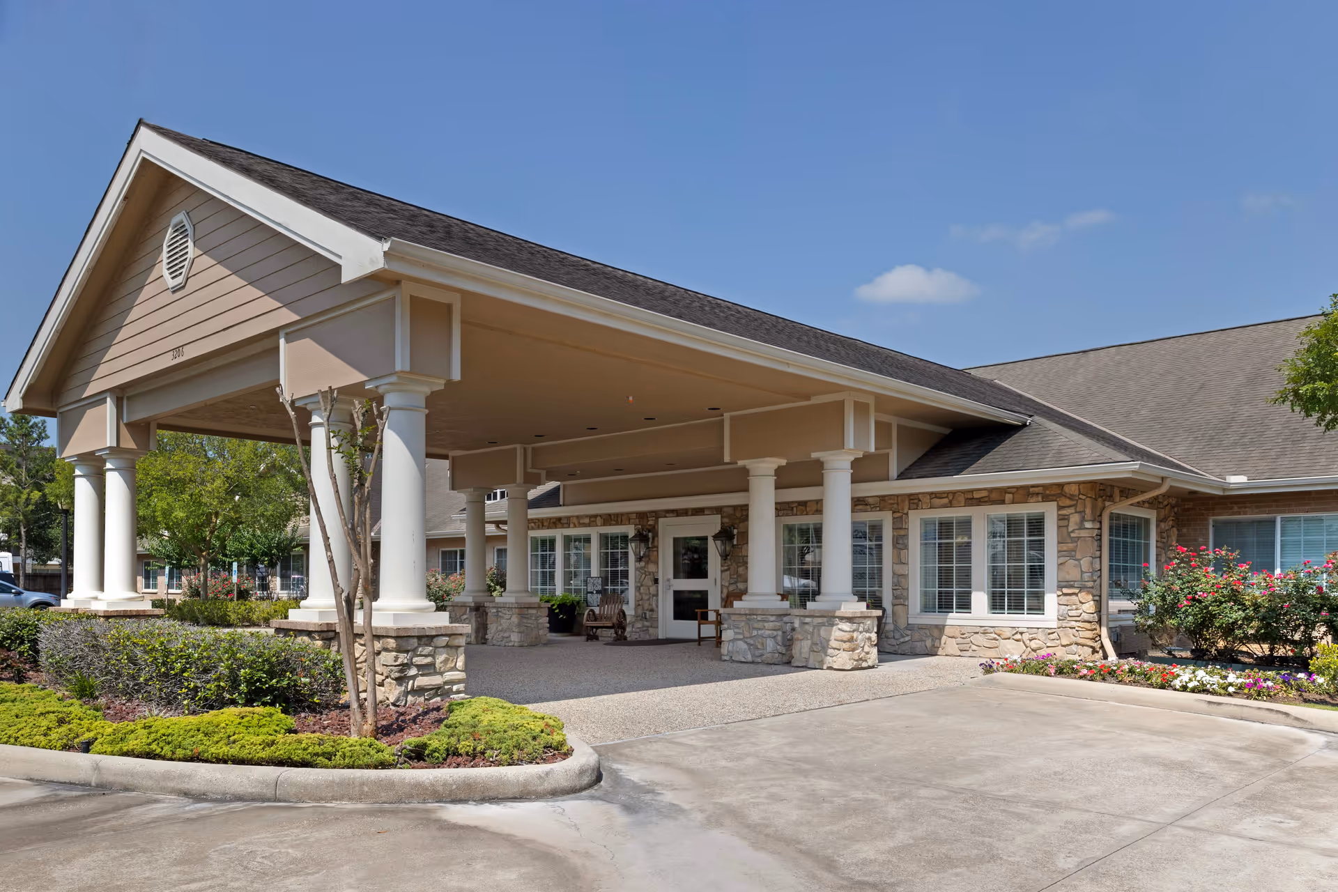 Exterior of Cedar Ridge Alzheimer's Special Care Center with a covered entrance and stone facade.
