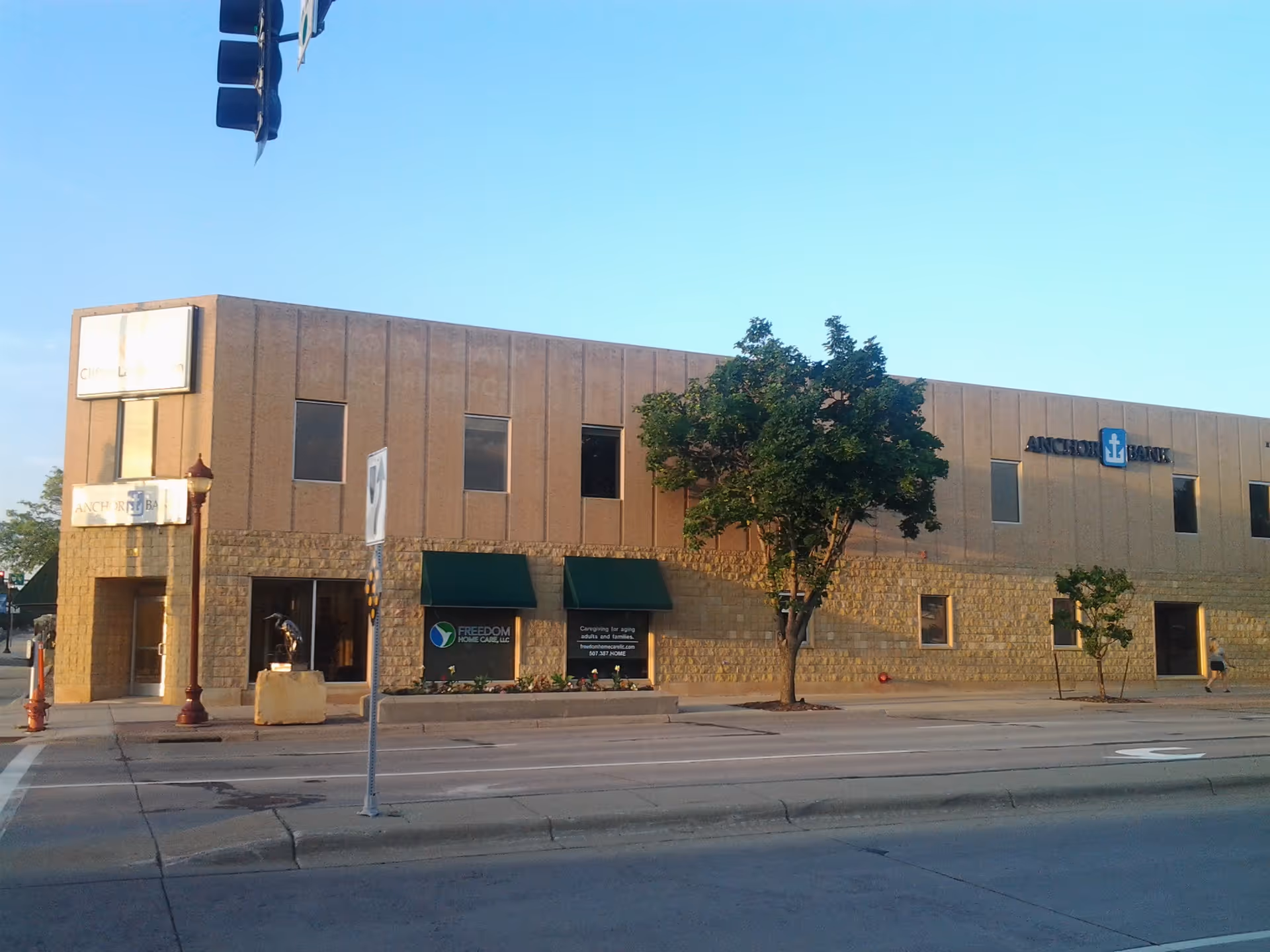 Exterior view of a beige commercial building with Freedom Home Care, LLC signage.