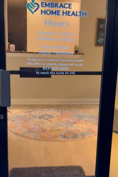 Interior entry area of Embrace Home Health with signage and a decorative circular rug.