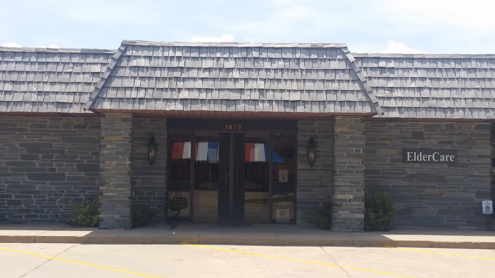 Stone exterior ElderCare entrance with glass doors and a wall sign.