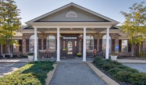 Front entrance of Maple Woods senior living facility with columns.