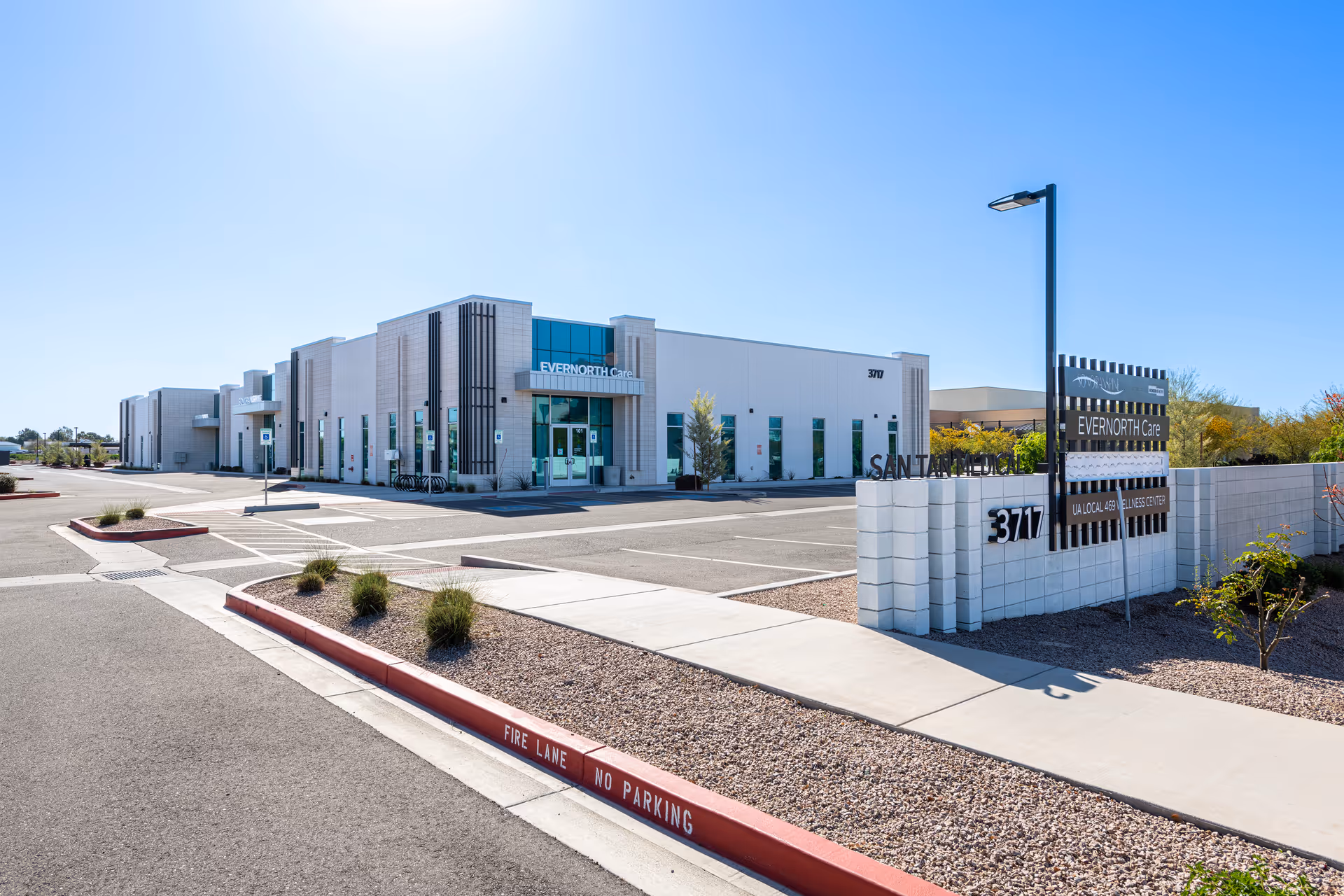 Exterior view of a modern medical facility with signage and parking.