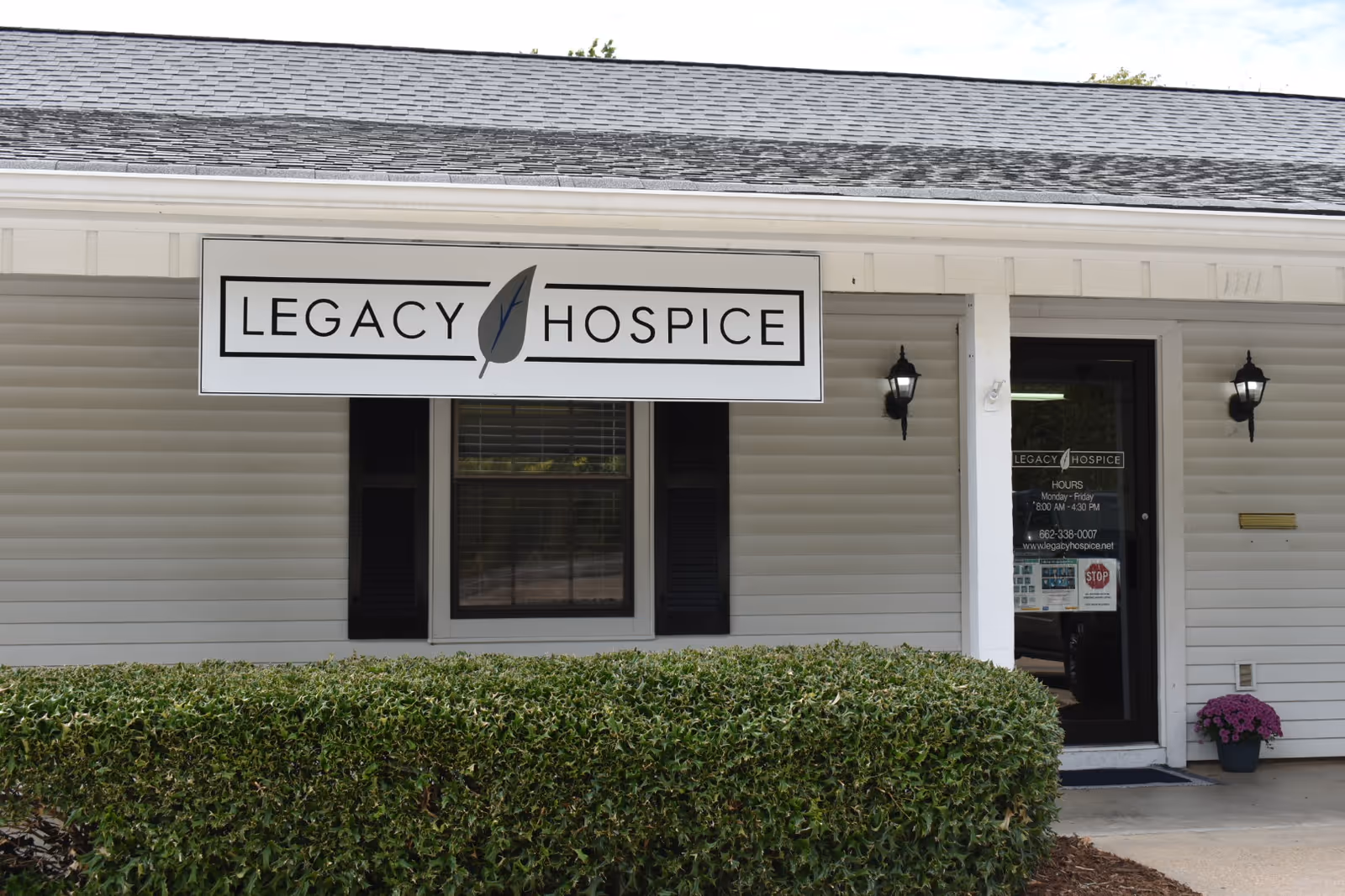 Front of a white building with Legacy Hospice sign and entrance.