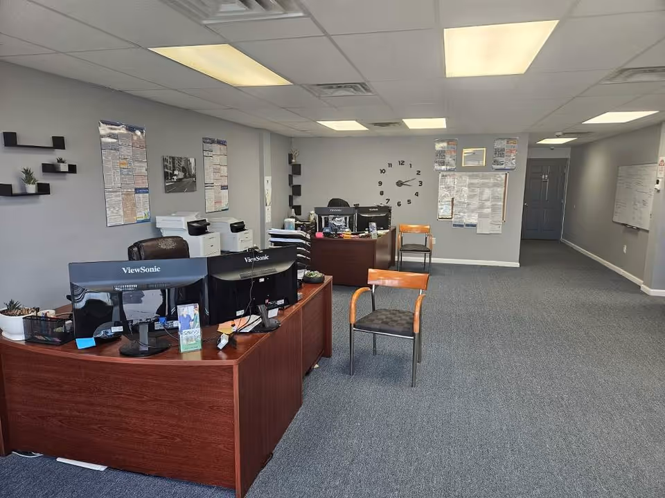 Reception area of Savvy Home Care with desks, computers, chairs, and wall clocks.