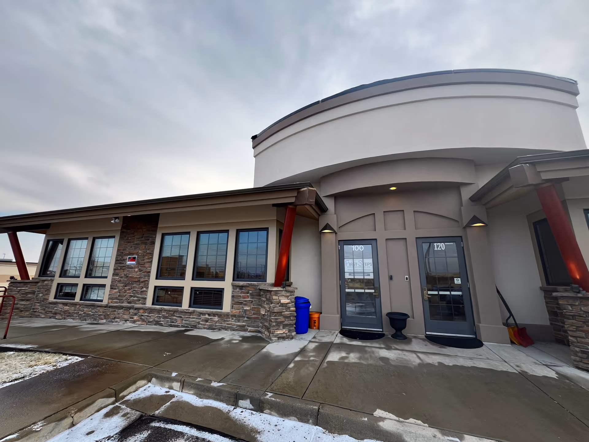 Exterior view of the First Steps Pediatric Therapy building entrance with curved architecture.