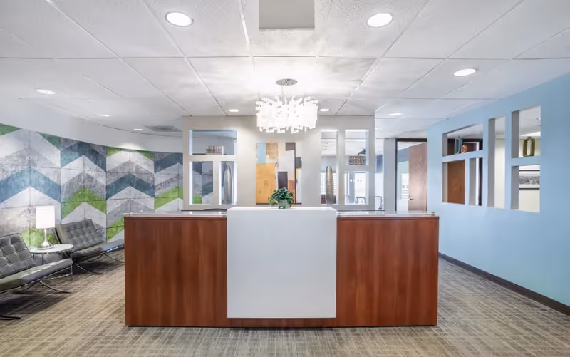 Noor Home Care lobby with a modern reception desk, seating, and geometric wall art.