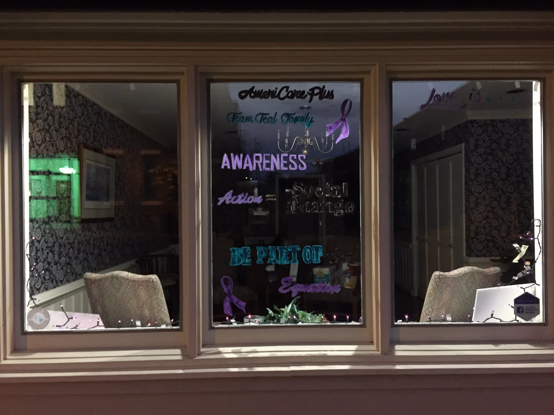 Window display at AmeriCare Plus Lexington showing interior seating and awareness-themed decor.