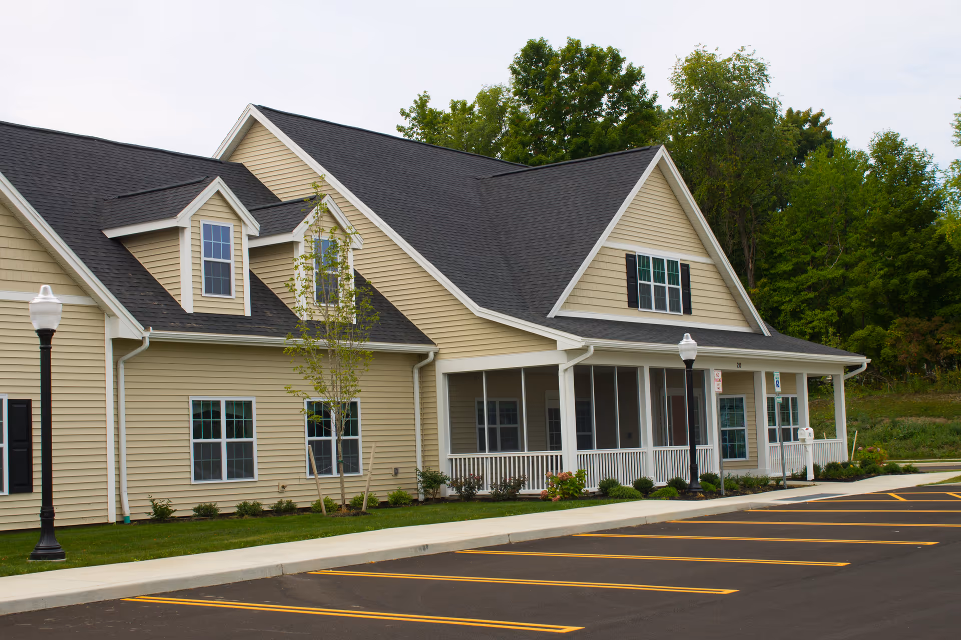 A beige senior living facility with a pitched roof and a covered front porch.