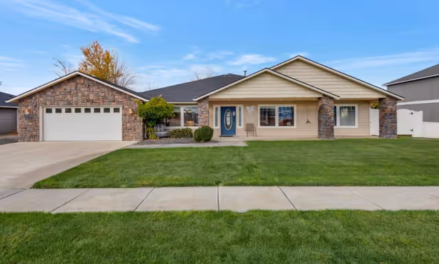 Single-story facility exterior with brick and siding, attached garage, and well-kept lawn.