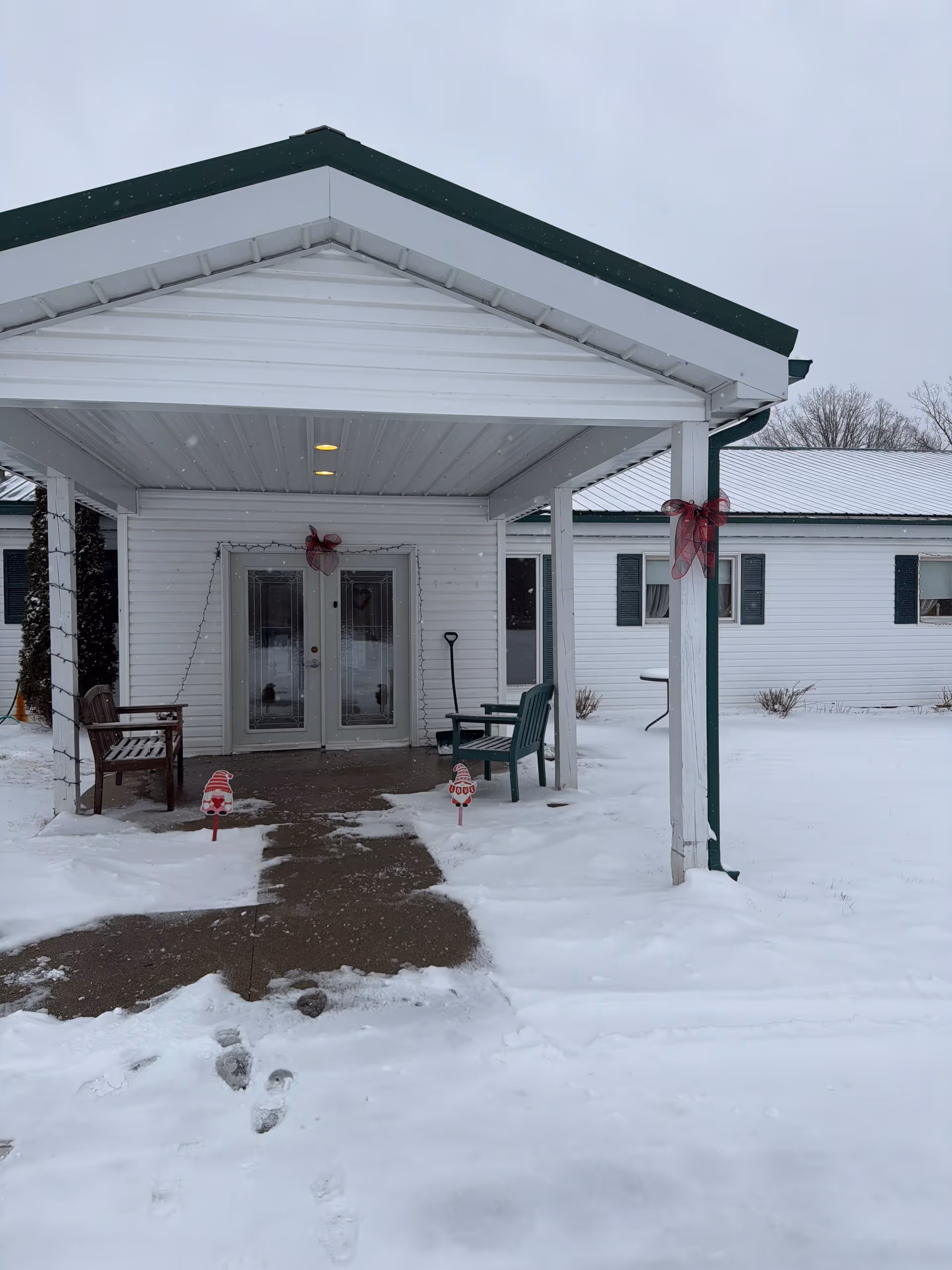Snow blankets the Gates AFC facility entrance, featuring a covered porch and seating.