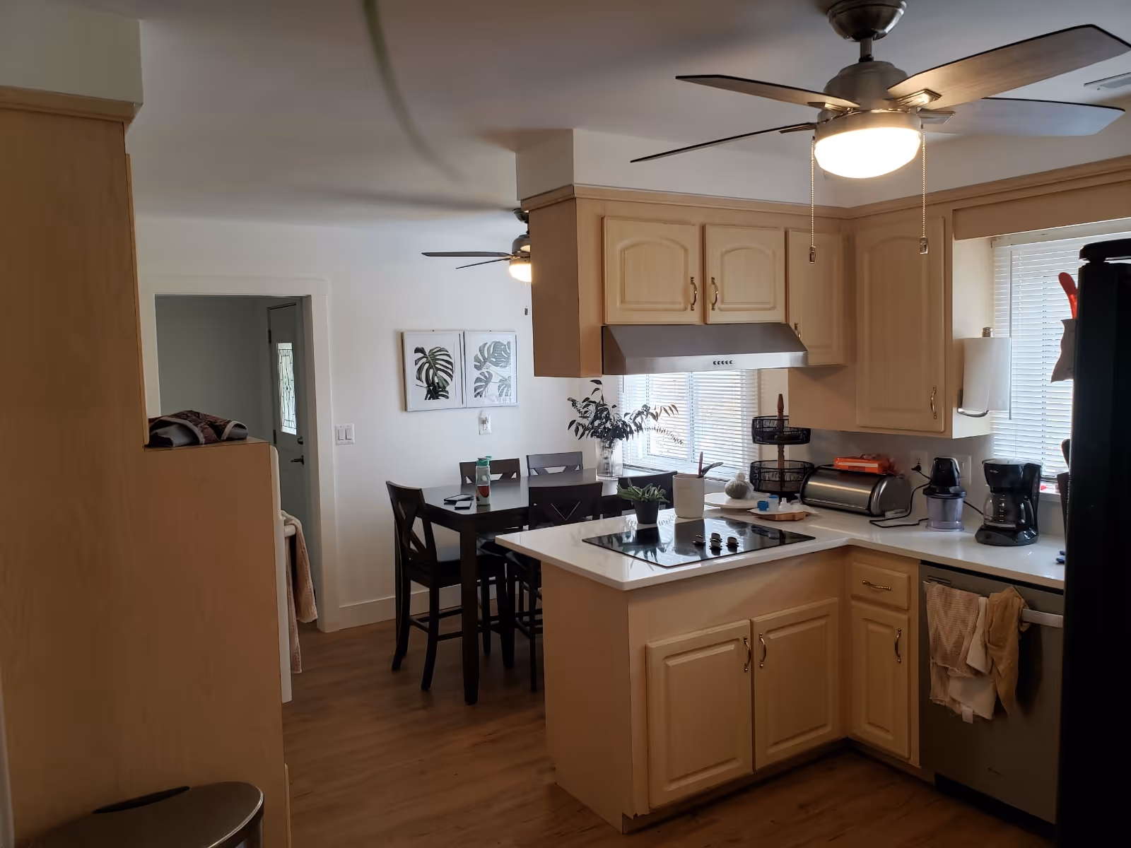 Bright kitchen with wooden cabinets, an island stove, and a nearby dining table.