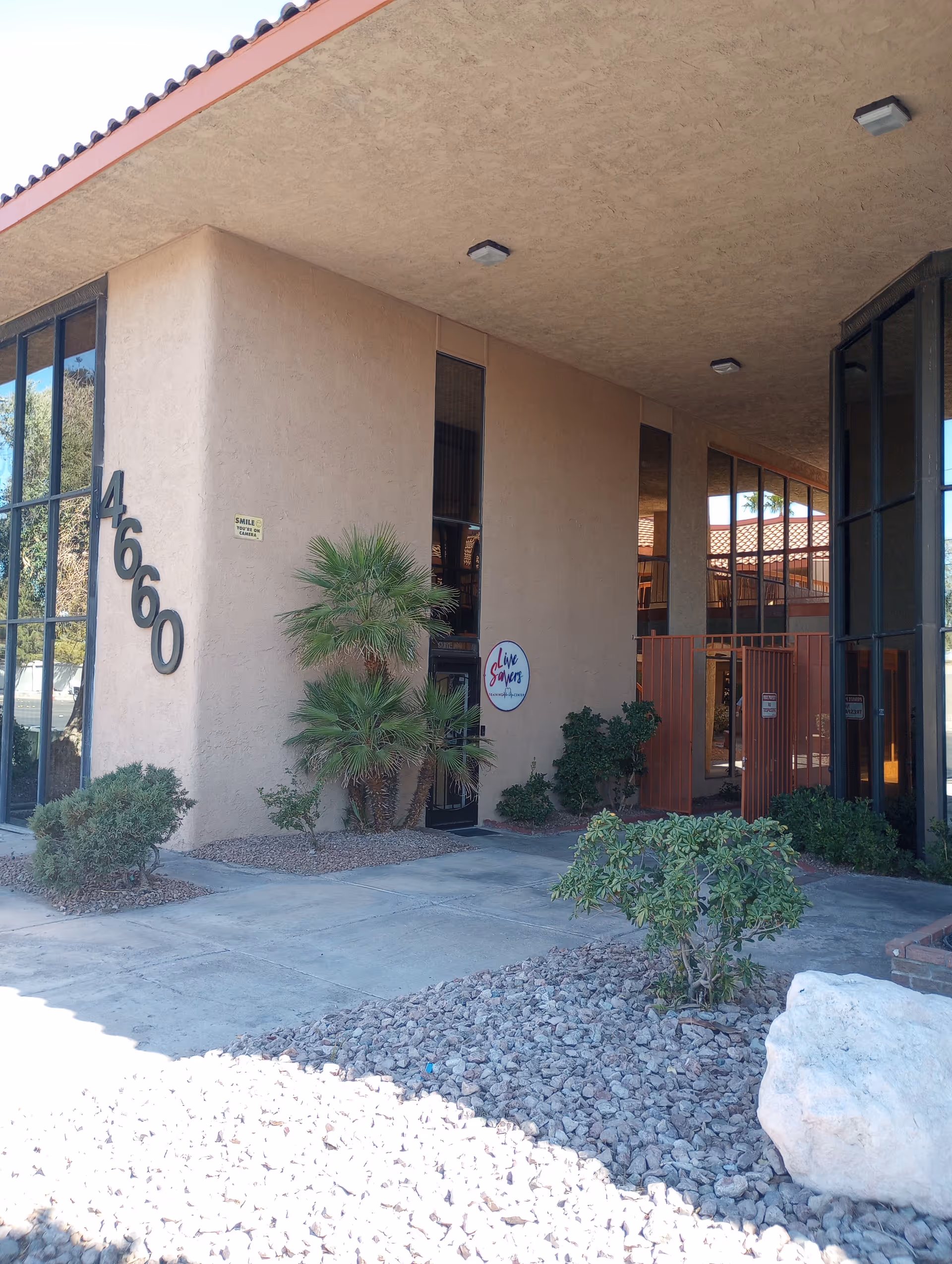 Exterior view of a senior living facility entrance with desert landscaping.