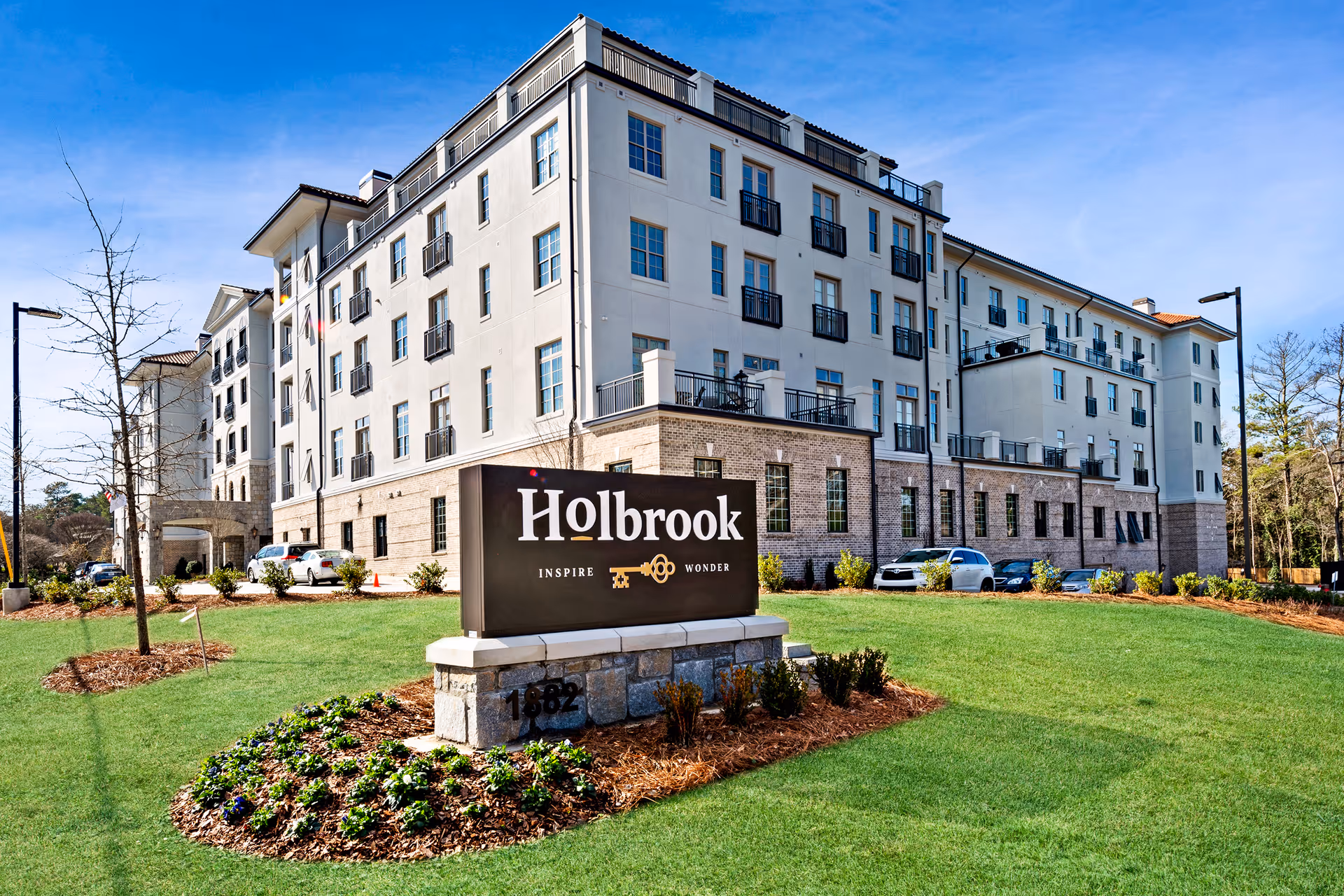 Exterior view of Holbrook Decatur senior living building with a front sign and green lawn.