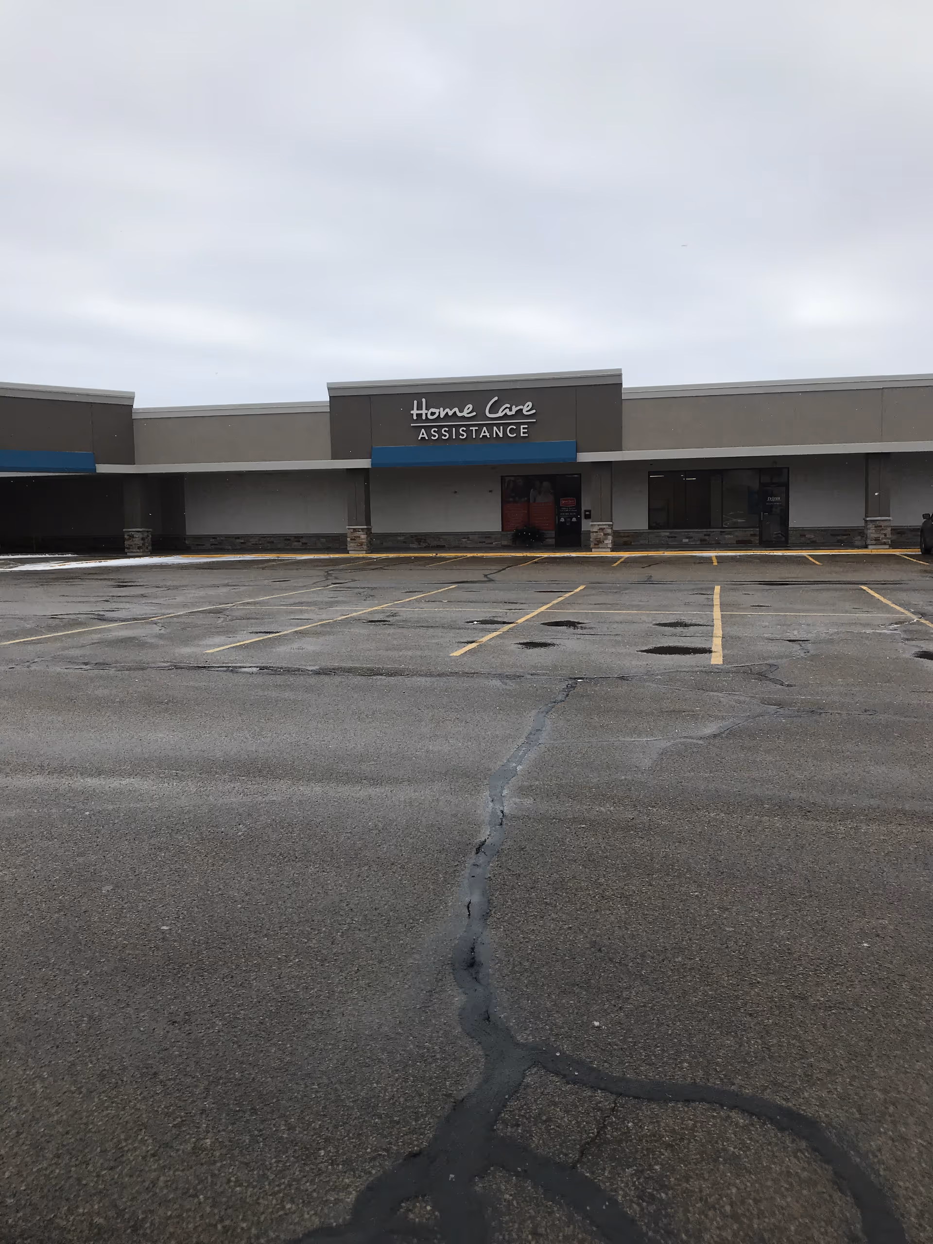Exterior view of a senior care building with a parking lot and Home Care sign.
