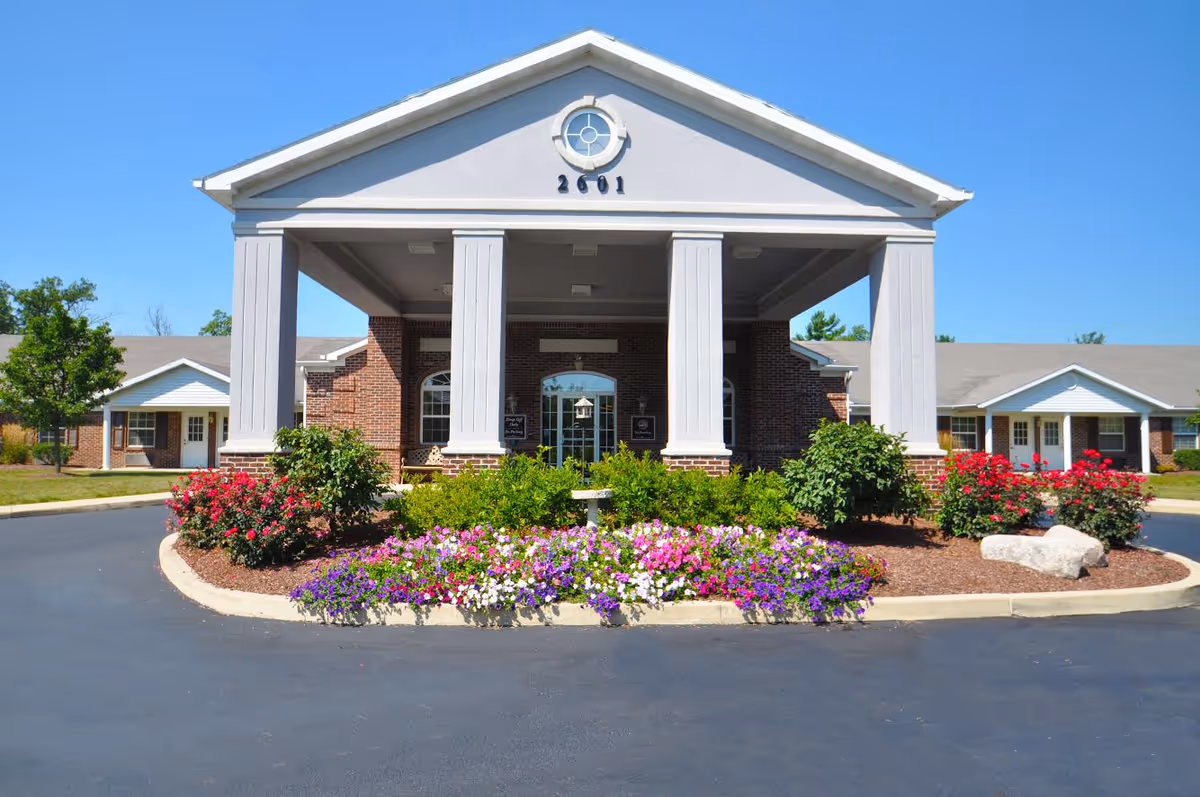 Front entrance of a senior living facility with colorful landscaping