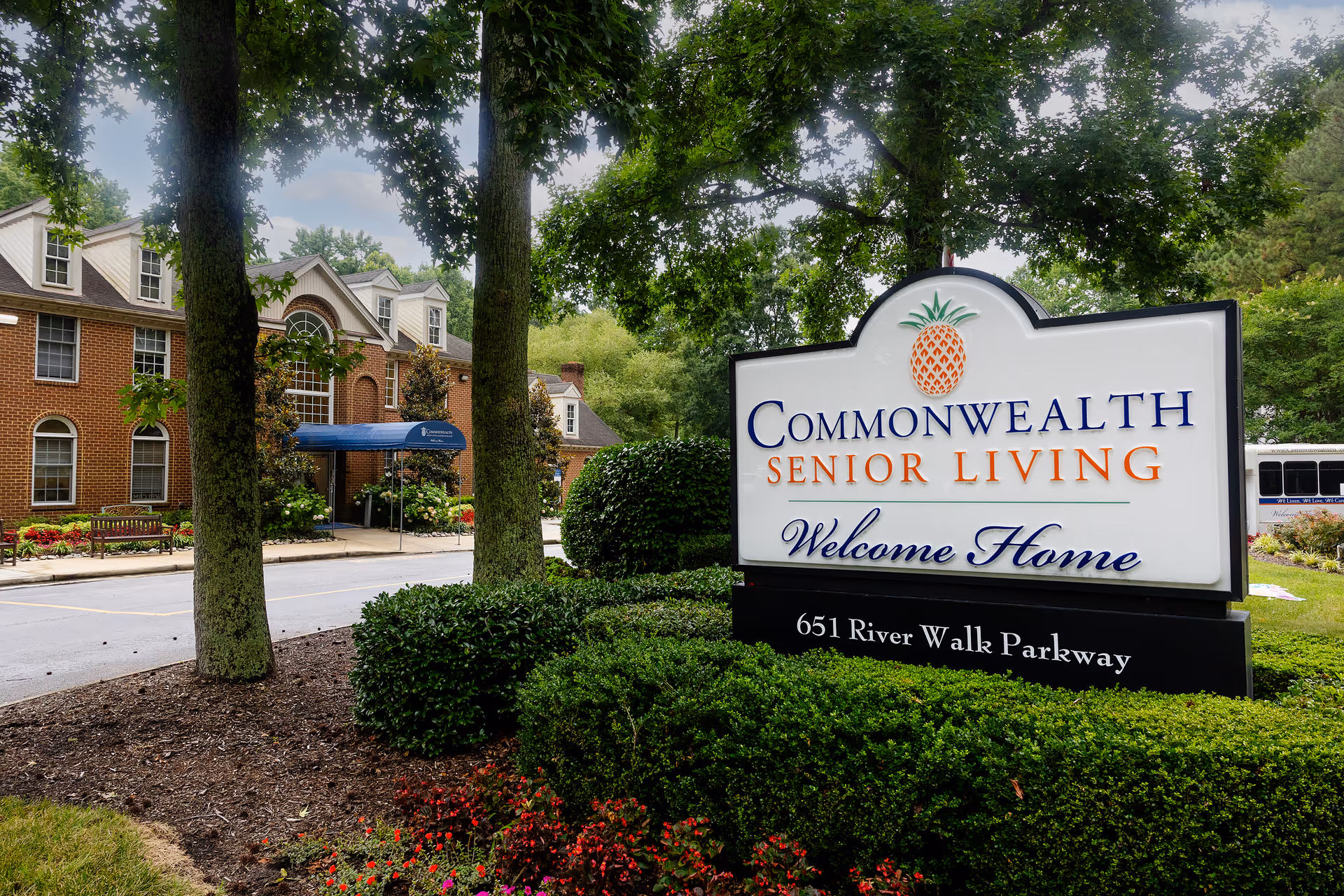Front view of Commonwealth Senior Living at Georgian Manor with welcoming sign and brick building.