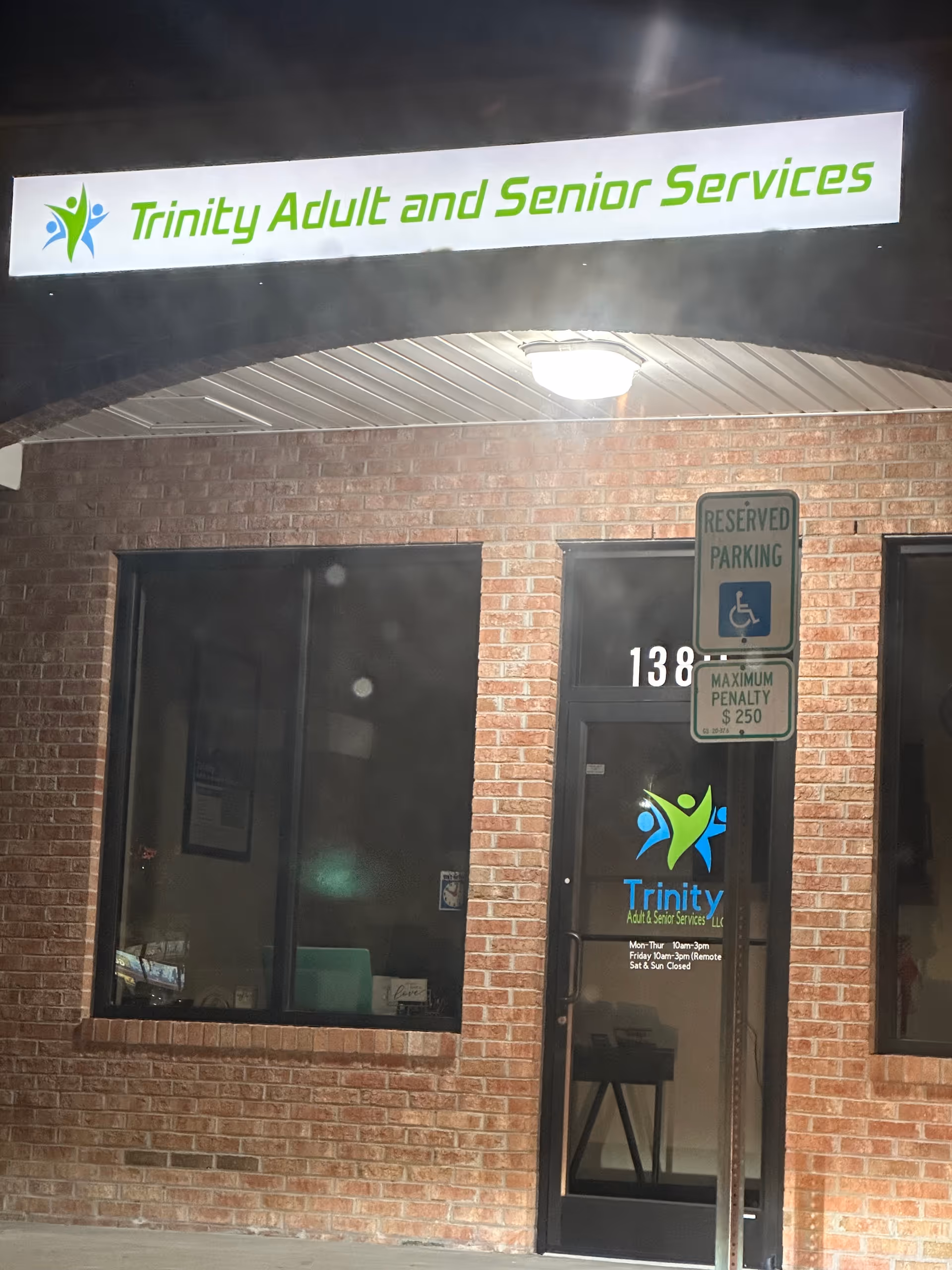 Exterior brick building with Trinity Adult and Senior Services LLC sign above glass entrance.