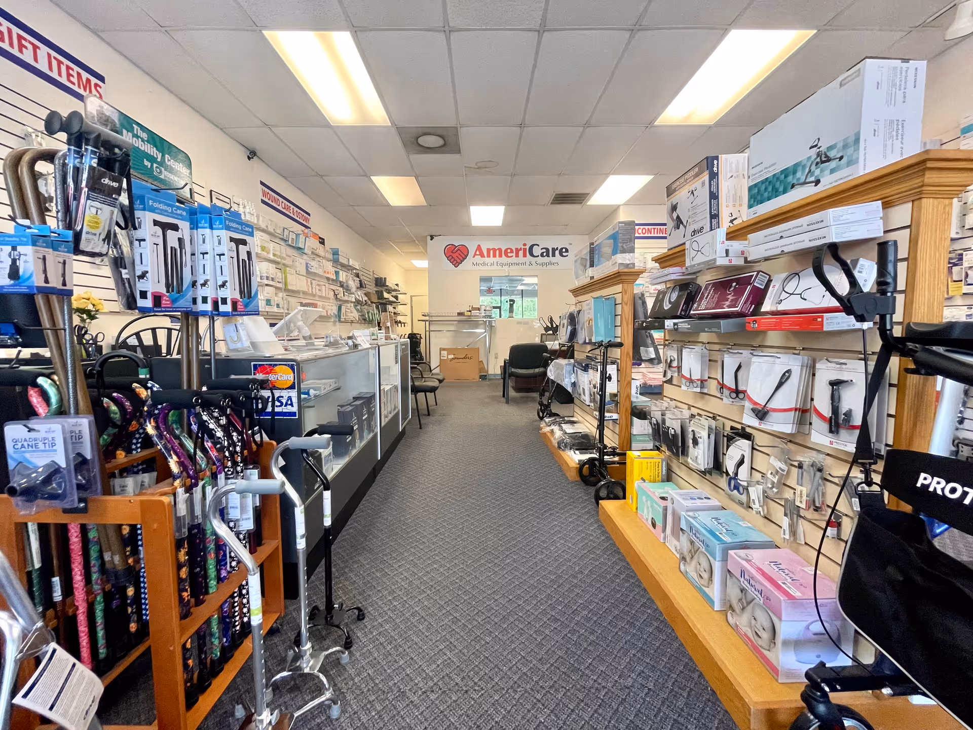 Narrow aisle in a medical supply shop featuring walkers, canes, and assistive devices