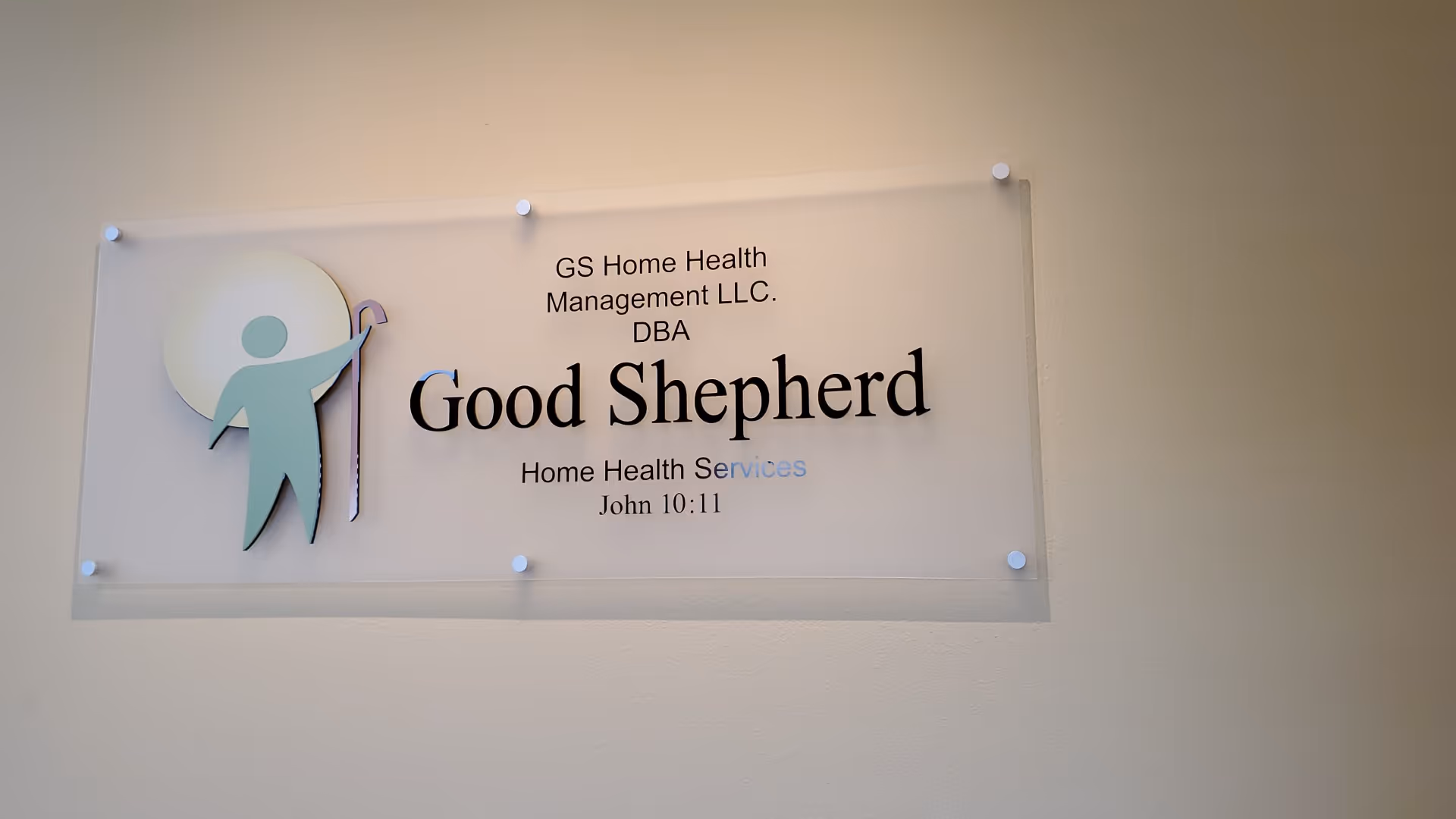 Clear wall sign reads Good Shepherd Home Health Services logo mounted on beige wall.