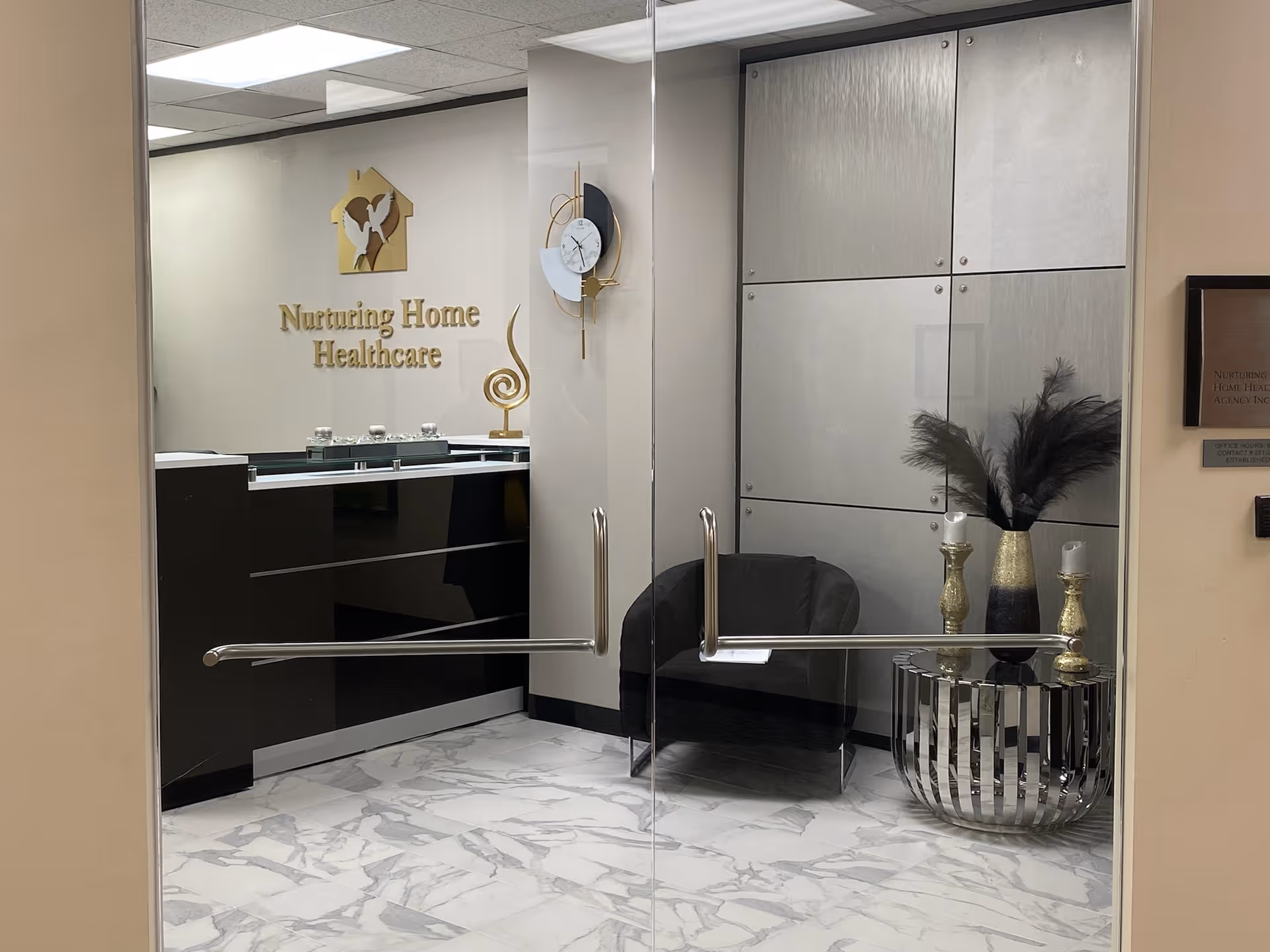Glass doors open to a modern reception area with a sign reading Nurturing Home Healthcare.