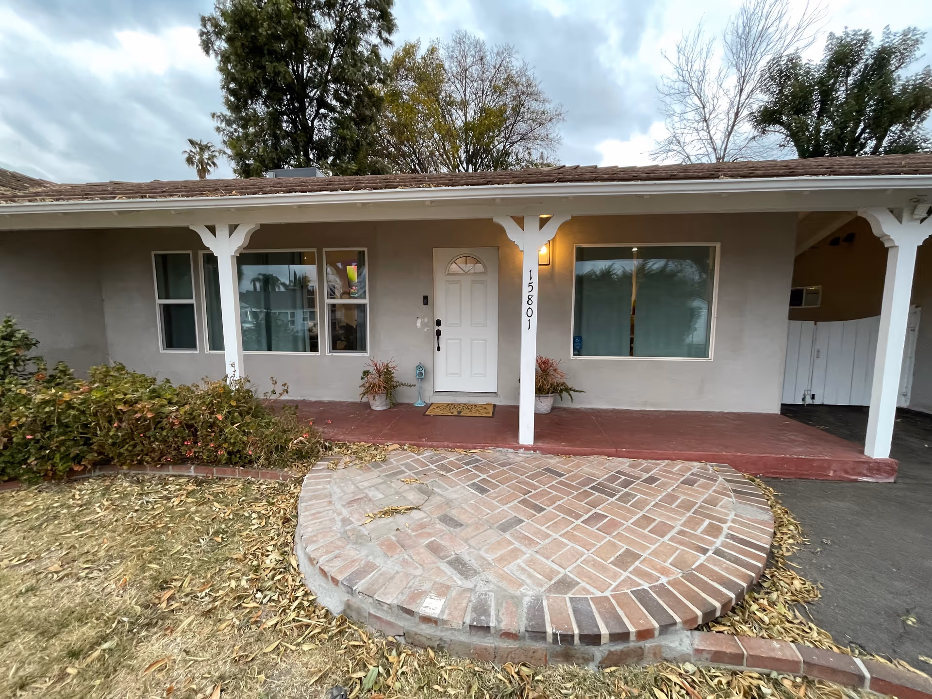 Front view of Nirvana Gardens Assisted Living facility with porch and curved brick walkway