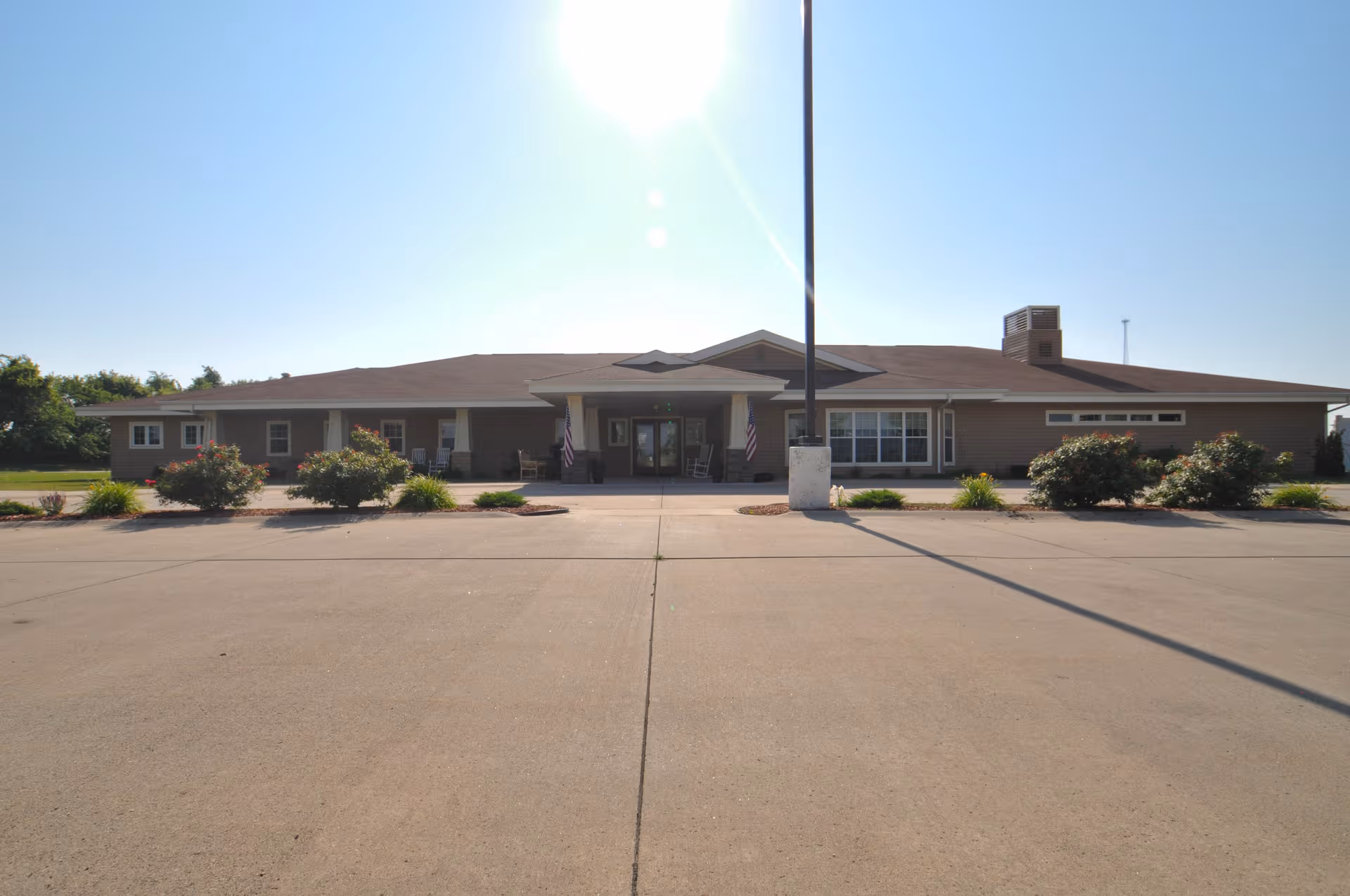 Single-story Windsor Manor exterior with entrance, parking lot, and landscaped front.