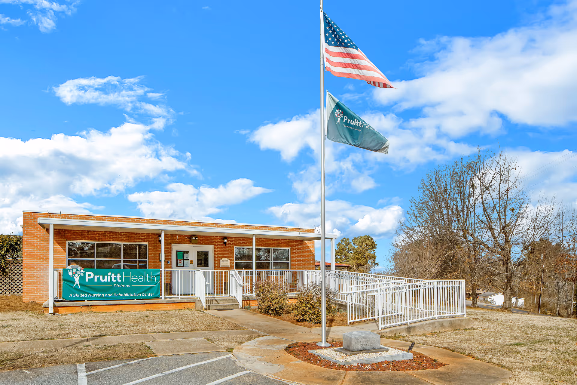 Exterior of PruittHealth Pickens, brick facility with flags and ramp.