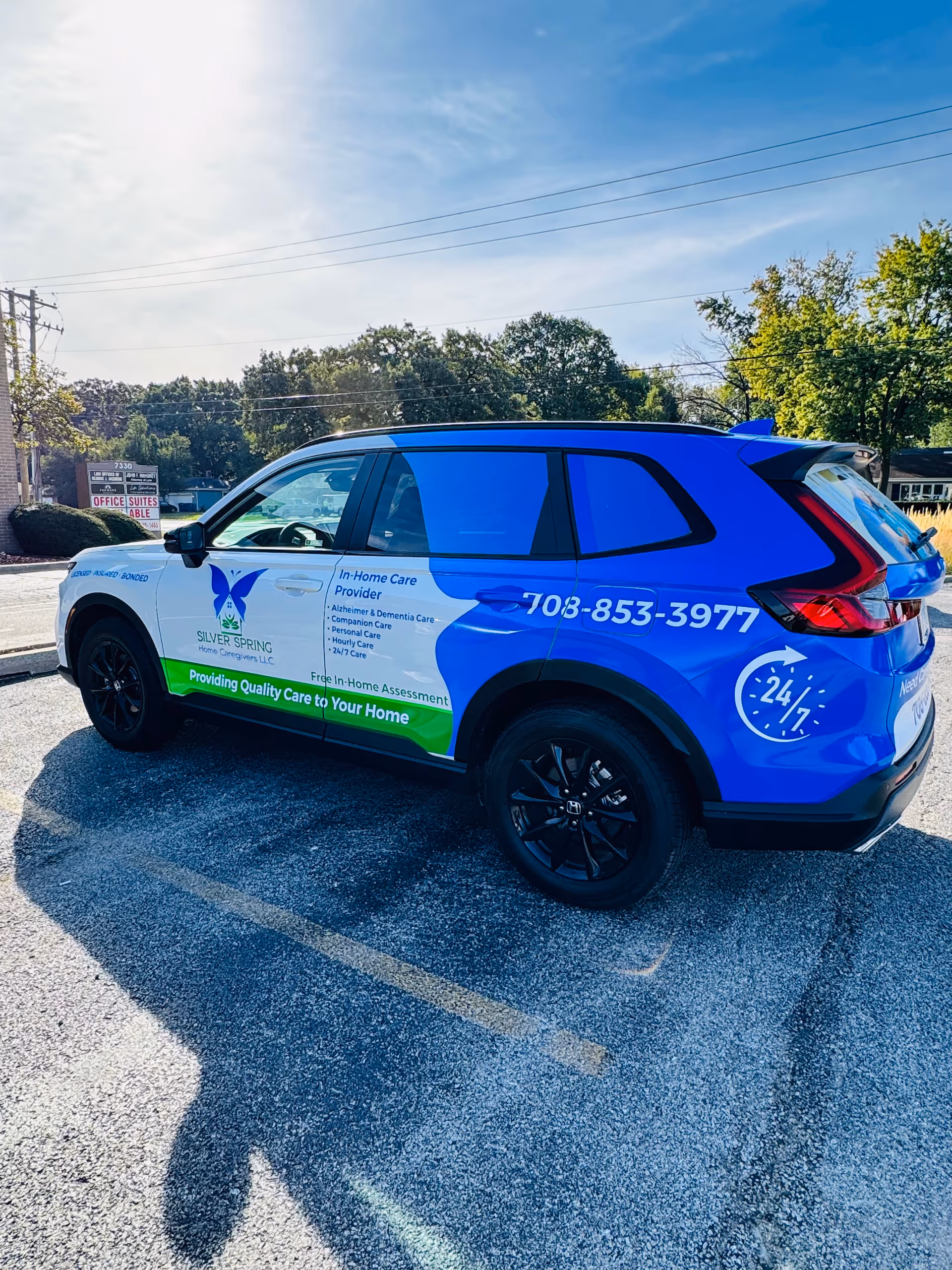 Blue vehicle with Silver Spring Home Caregivers branding parked outdoors.