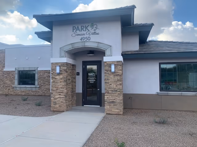 Exterior view of Park Senior Villas entrance with stone columns and a glass door.