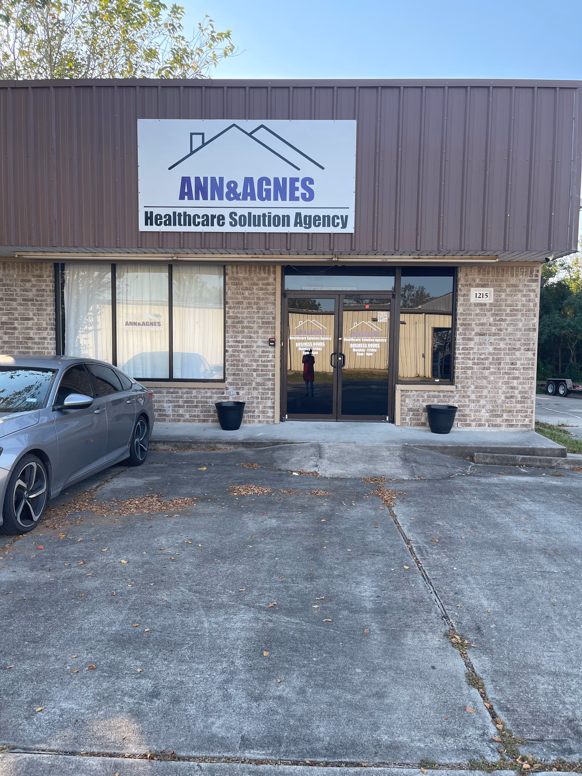 Front view of ANN&AGNES Healthcare Solution Agency storefront with a parked car.